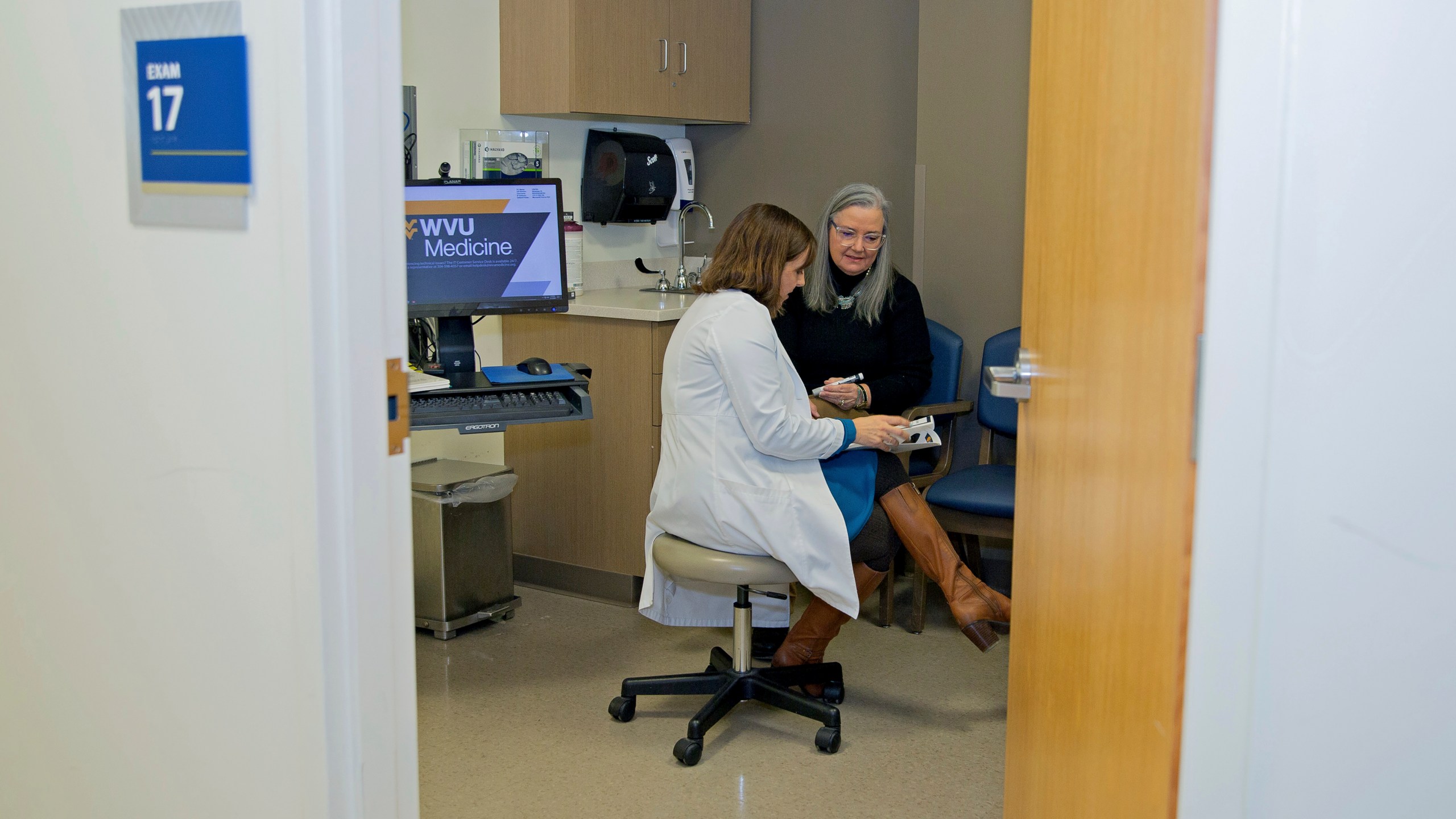 Patient Lory Osborn (right) speaks with Dr. Laura Davisson, director of the Medical Weight Management at West Virginia University in Morgantown, W.Va., Monday, Dec. 2, 2024. (AP Photo/Kathleen Batten)