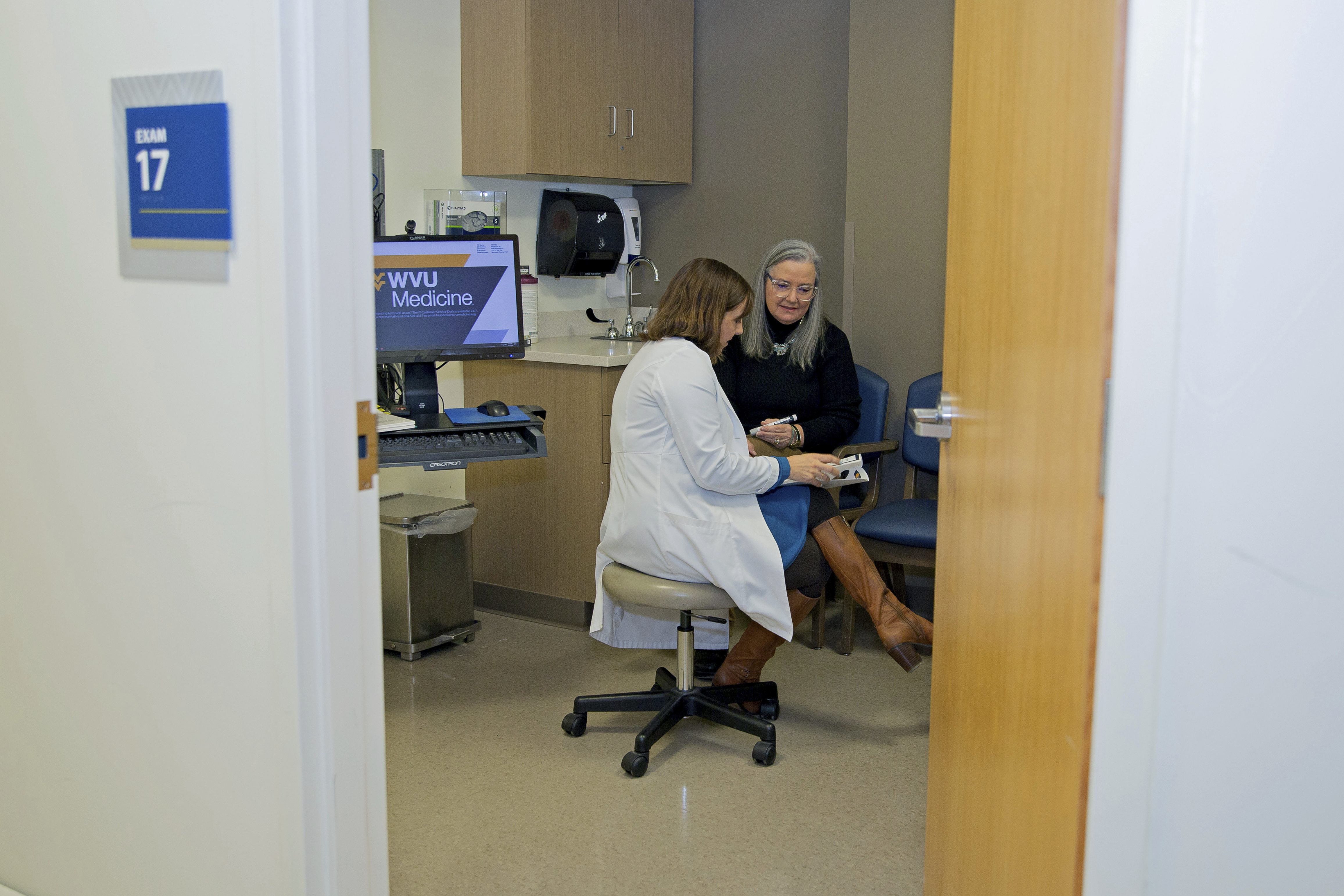 Patient Lory Osborn (right) speaks with Dr. Laura Davisson, director of the Medical Weight Management at West Virginia University in Morgantown, W.Va., Monday, Dec. 2, 2024. (AP Photo/Kathleen Batten)