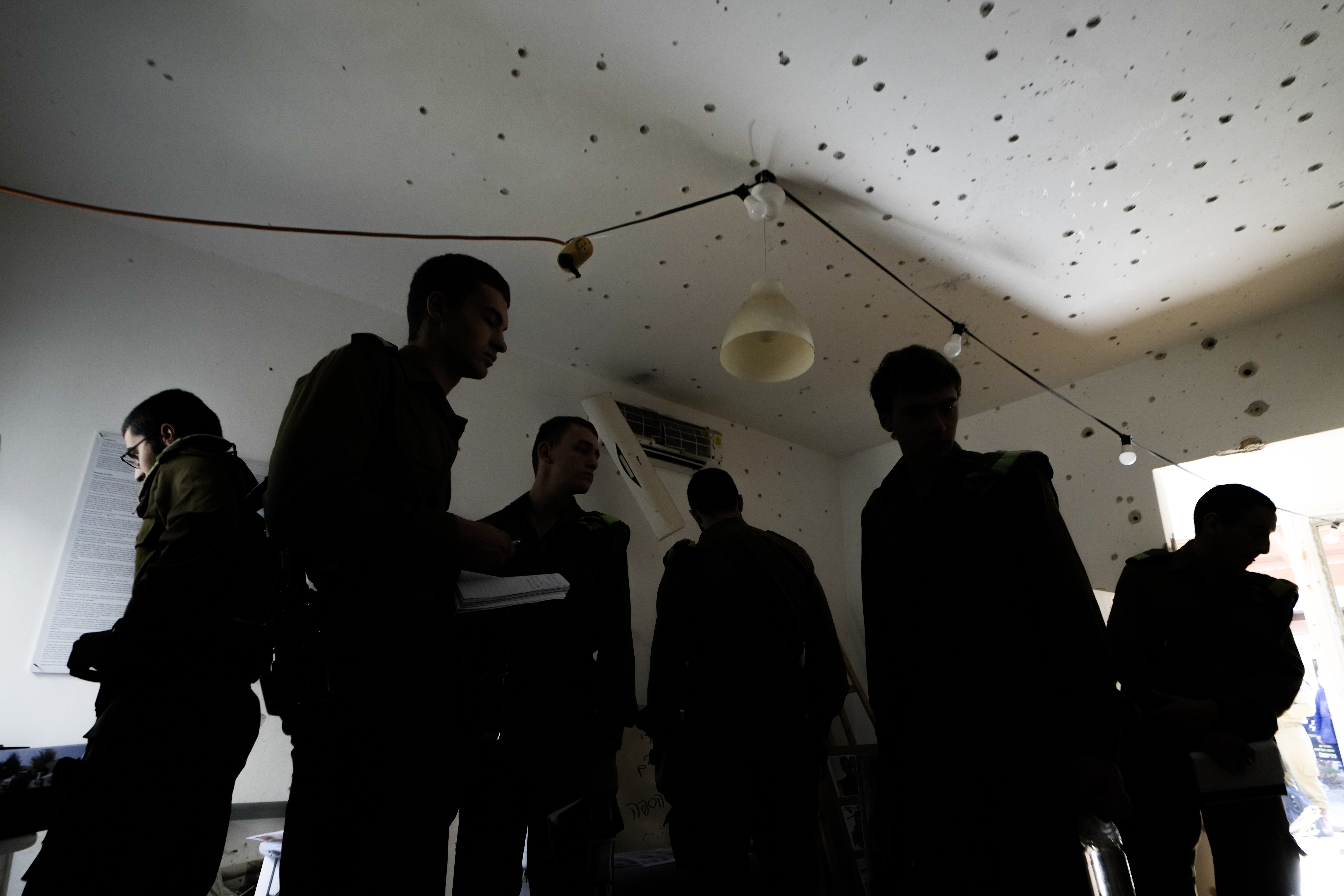 Israeli soldiers stand in a bullet-ridden house during a tour for army personnel to observe the damage caused by the Oct. 7 Hamas onslaught at Kibbutz Kfar Aza, near the Israeli-Gaza border, in Israel, Thursday, Jan. 2, 2025. (AP Photo/Matias Delacroix)