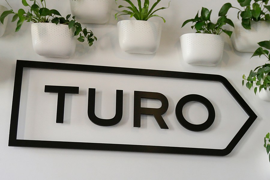 FILE - The Turo logo is shown in the entryway of Turo in San Francisco, April 29, 2019. (AP Photo/Eric Risberg, File)