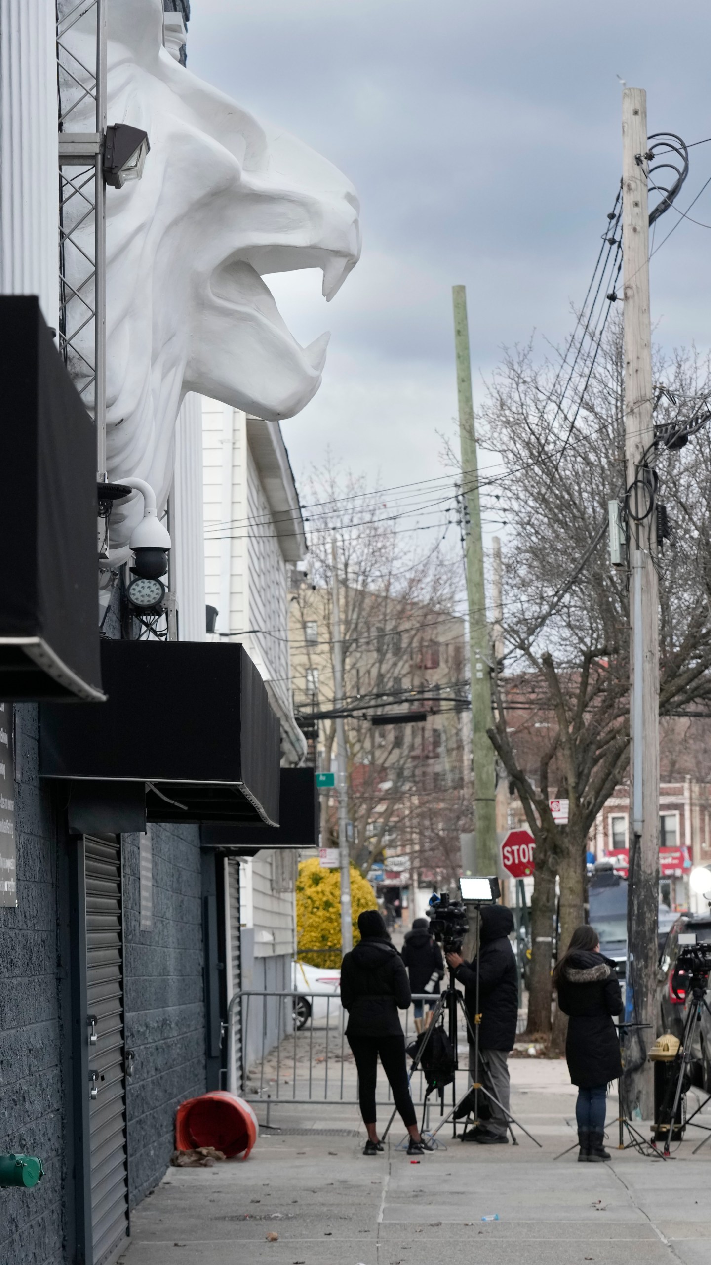 Members of the media work in front of the nightclub Amazura, left, in the Queens borough of New York, Thursday, Jan. 2, 2025. (AP Photo/Seth Wenig)