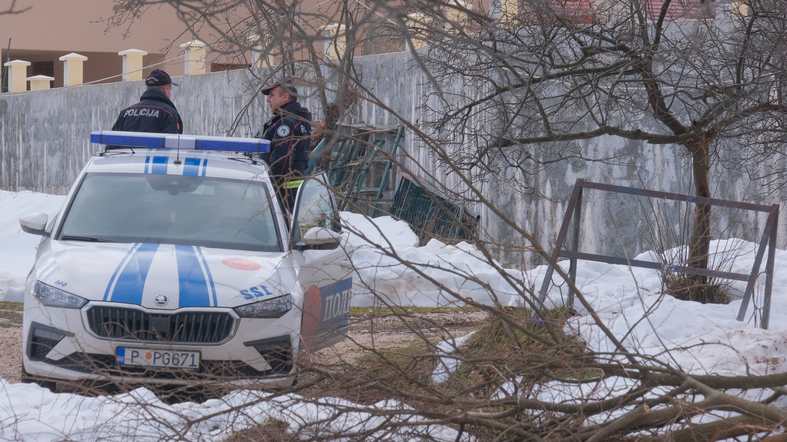 Police officers stand guard at the home of a gunman after a shooting incident, in Cetinje, 36 kilometers (22 miles) west of Podogrica, Montenegro, Thursday, Jan. 2, 2025. (AP Photo/Risto Bozovic)