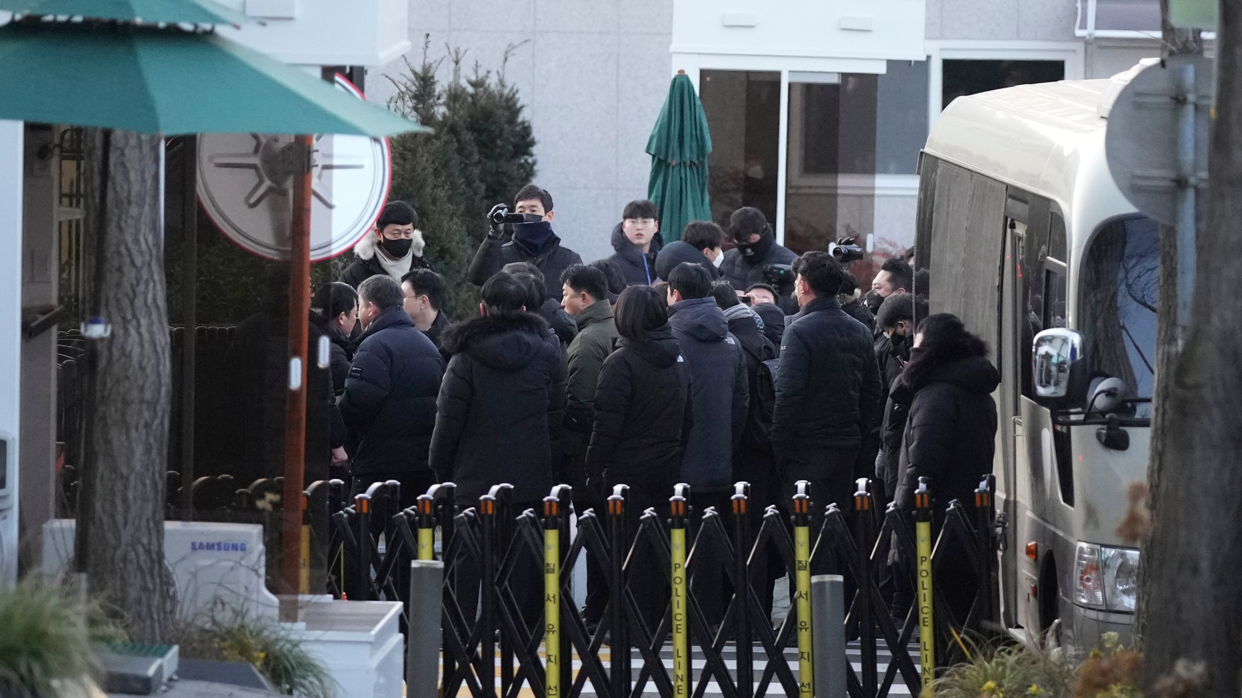 Investigators from the Corruption Investigation Office for High-ranking Officials arrive at the gate of the presidential residence as supporters of impeached South Korean President Yoon Suk Yeol stage a rally to oppose a court having issued a warrant to detain Yoon, in Seoul, South Korea, Friday, Jan. 3, 2025. (AP Photo/Lee Jin-man)