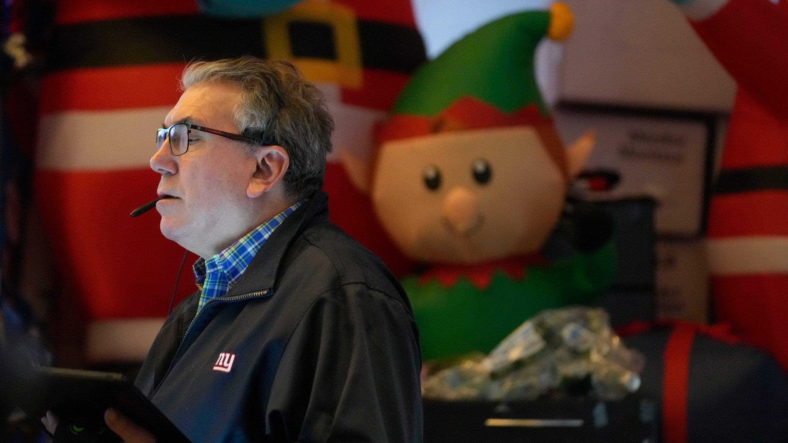 A trader works amid Christmas decorations on the floor at the New York Stock Exchange in New York's Financial District Thursday, Jan. 2, 2025. (AP Photo/Seth Wenig)