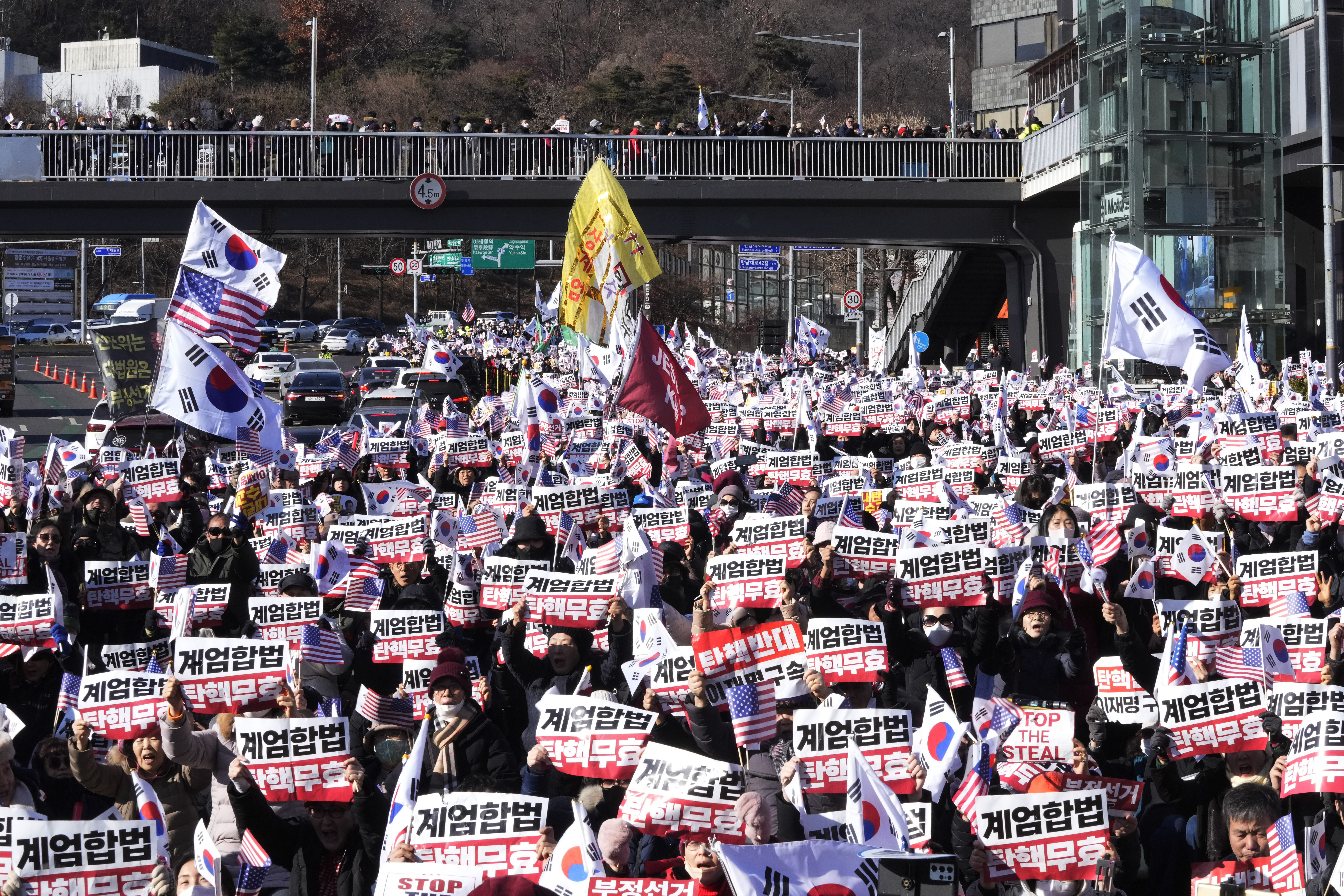 Supporters of impeached South Korean President Yoon Suk Yeol stage a rally to oppose a court having issued a warrant to detain Yoon, near the presidential residence in Seoul, South Korea, Thursday, Jan. 2, 2025. The signs read, "Oppose impeachment." (AP Photo/Ahn Young-joon)