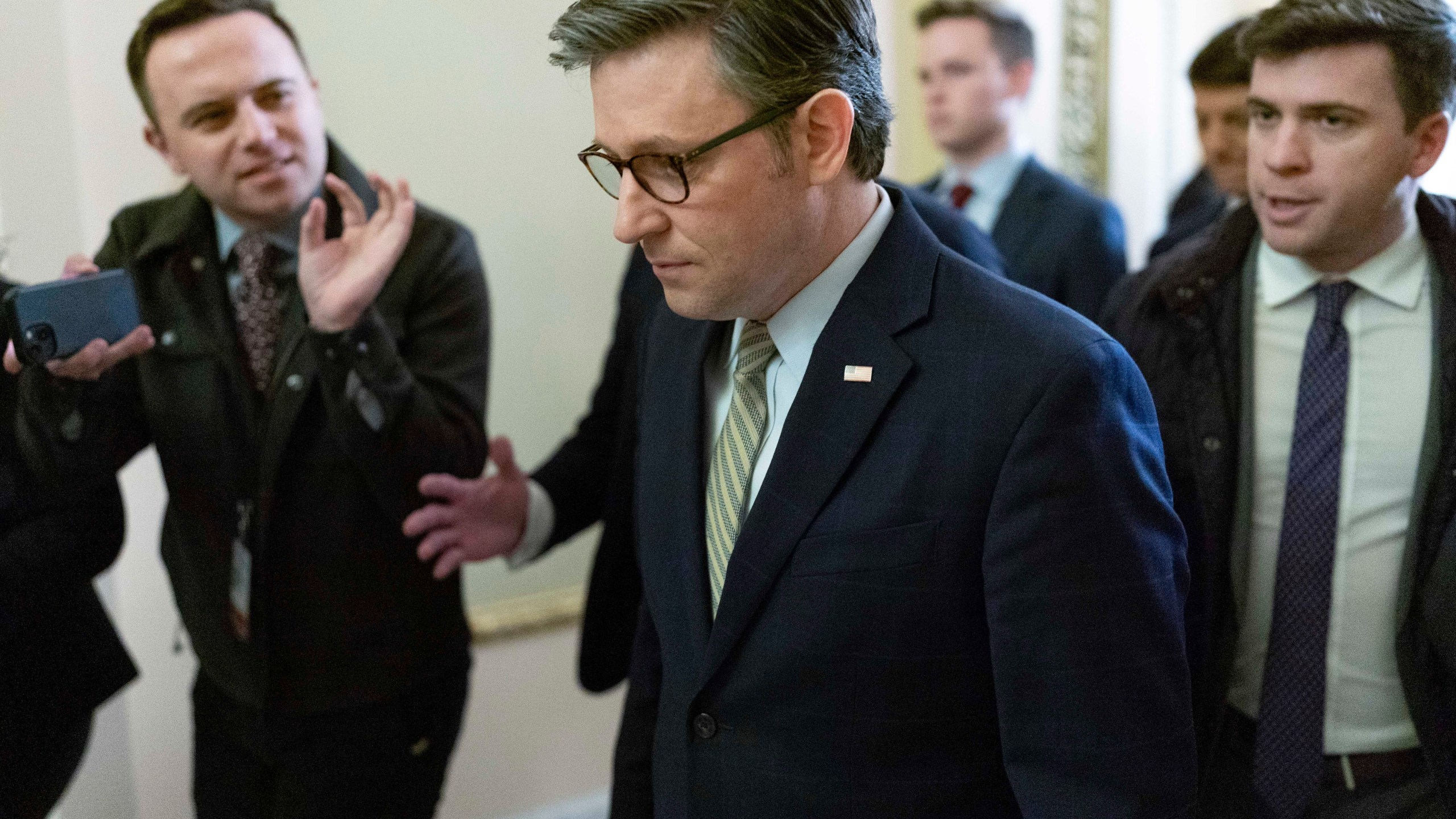 Speaker of the House Mike Johnson, R-La., followed by reporters, walks to the House Chamber at the Capitol in Washington, Friday, Dec. 20, 2024. (AP Photo/Jose Luis Magana)