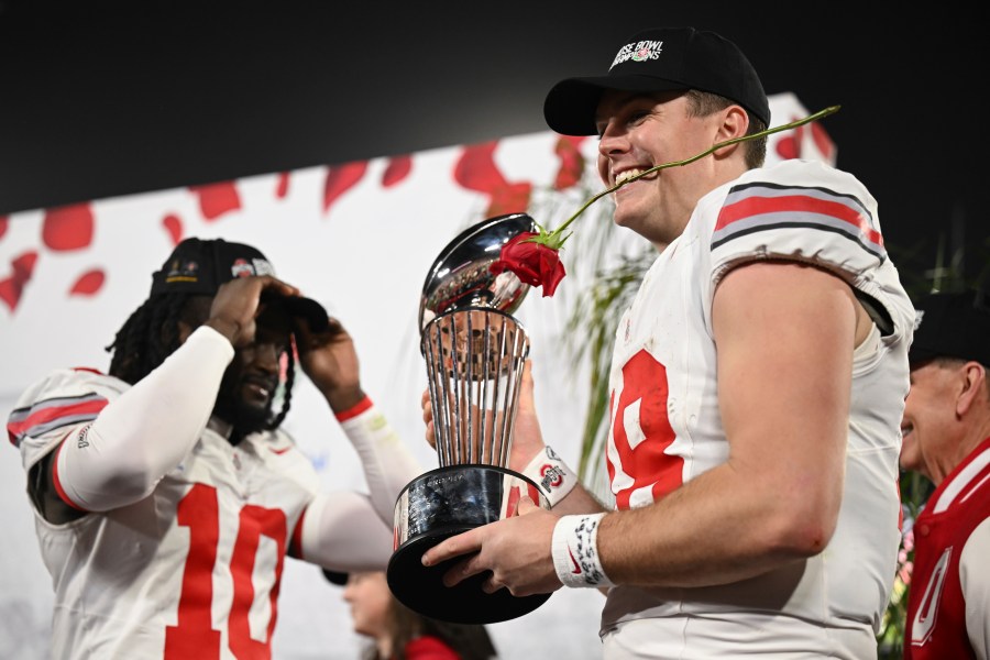 Ohio State quarterback Will Howard (18) celebrates with the trophy after the quarterfinals of the Rose Bowl College Football Playoff against Oregon, Wednesday, Jan. 1, 2025, in Pasadena, Calif. (AP Photo/Kyusung Gong)