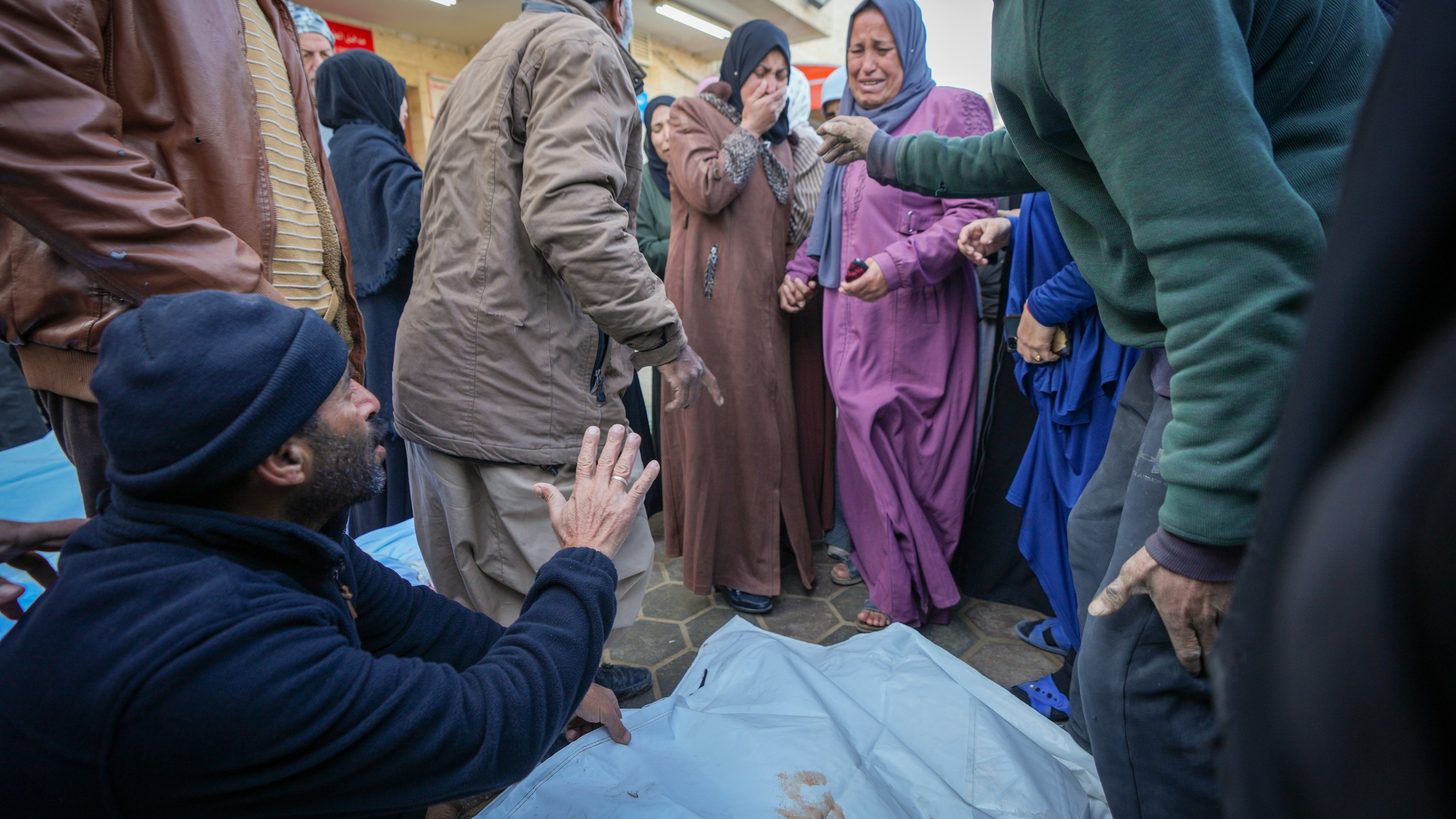 Relatives mourn as the bodies of victims from overnight Israeli army strikes at multiple locations in the central Gaza Strip are laid together for funeral prayers, at Al-Aqsa Martyrs Hospital in Deir al-Balah, Friday, Jan. 3, 2025. According to Al-Aqsa Martyrs Hospital, 30 people, including 10 women and 7 children, were killed in several attacks overnight in central Gaza. (AP Photo/Abdel Kareem Hana)