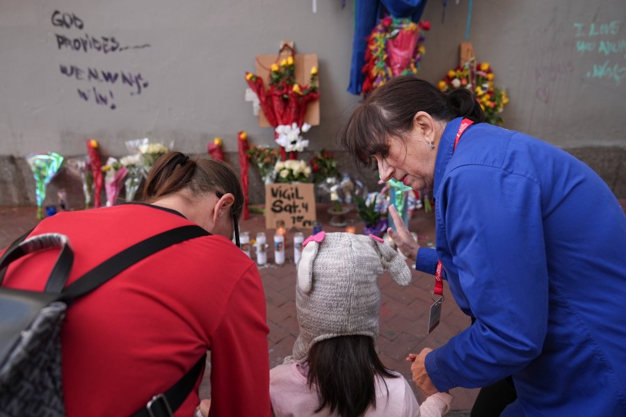 Allyson Tomkins, right, prays with Emily Lara, 5, center, and her grandmother Charity Lara, right, at a memorial to the victims of a deadly truck attack on Bourbon Street in the French Quarter, Friday, Jan. 3, 2025, in New Orleans. (AP Photo/George Walker IV)