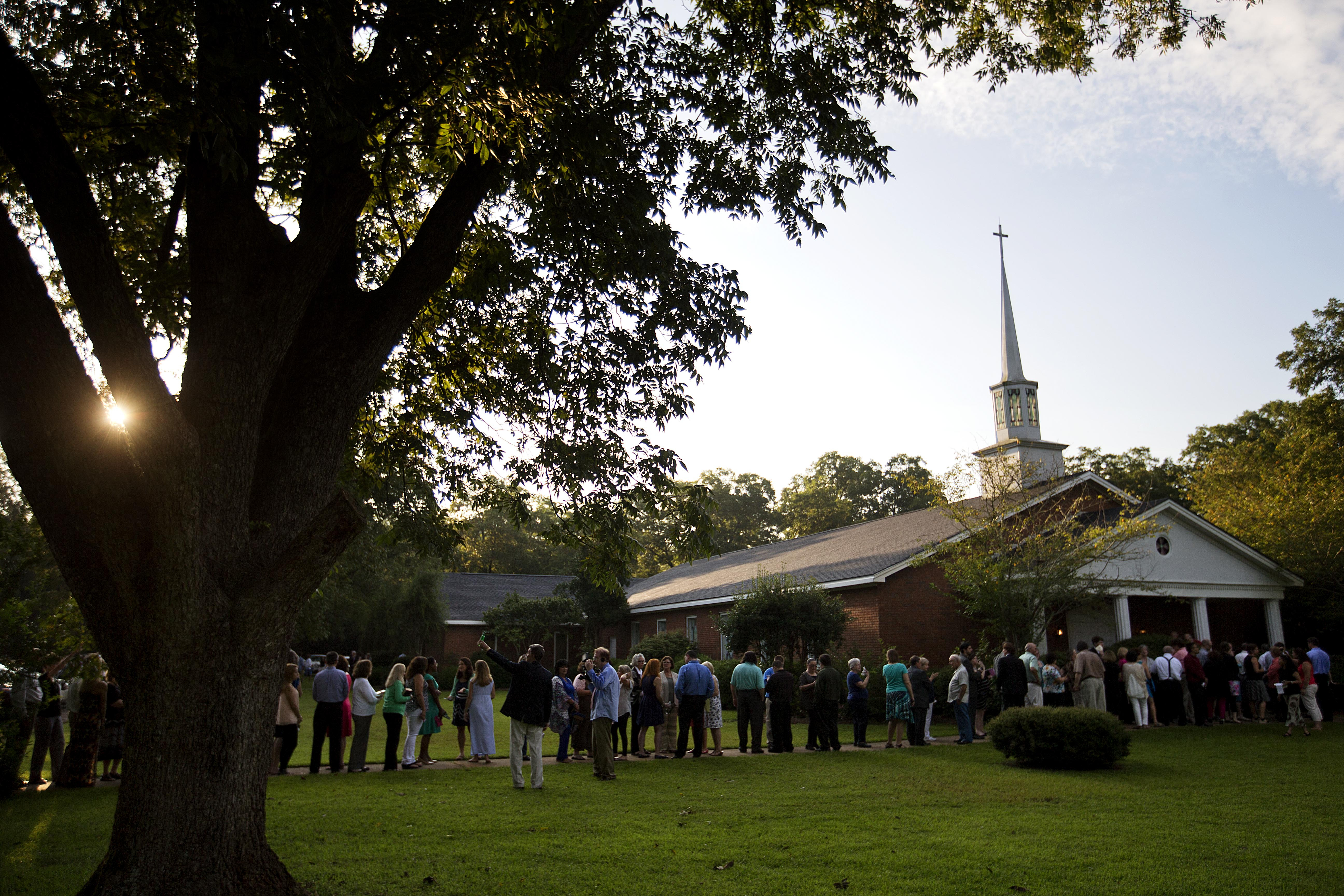 FILE - People wait in line outside Maranatha Baptist Church in Plains, Ga., to get into a Sunday school class taught by former U.S. President Jimmy Carter on Aug. 23, 2015. It was Carter's first lesson since announcing plans for intravenous drug doses and radiation to treat melanoma found in his brain after surgery to remove a tumor from his liver. (AP Photo/David Goldman, File)