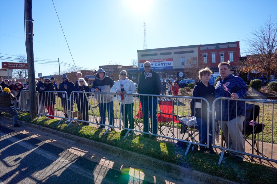 People line the street in Plains, Ga., before the hearse carrying the casket of former President Jimmy Carter passes through the town Saturday, Jan. 4, 2025. Carter died Dec. 29 at the age of 100. (AP Photo/Alex Brandon, Pool)