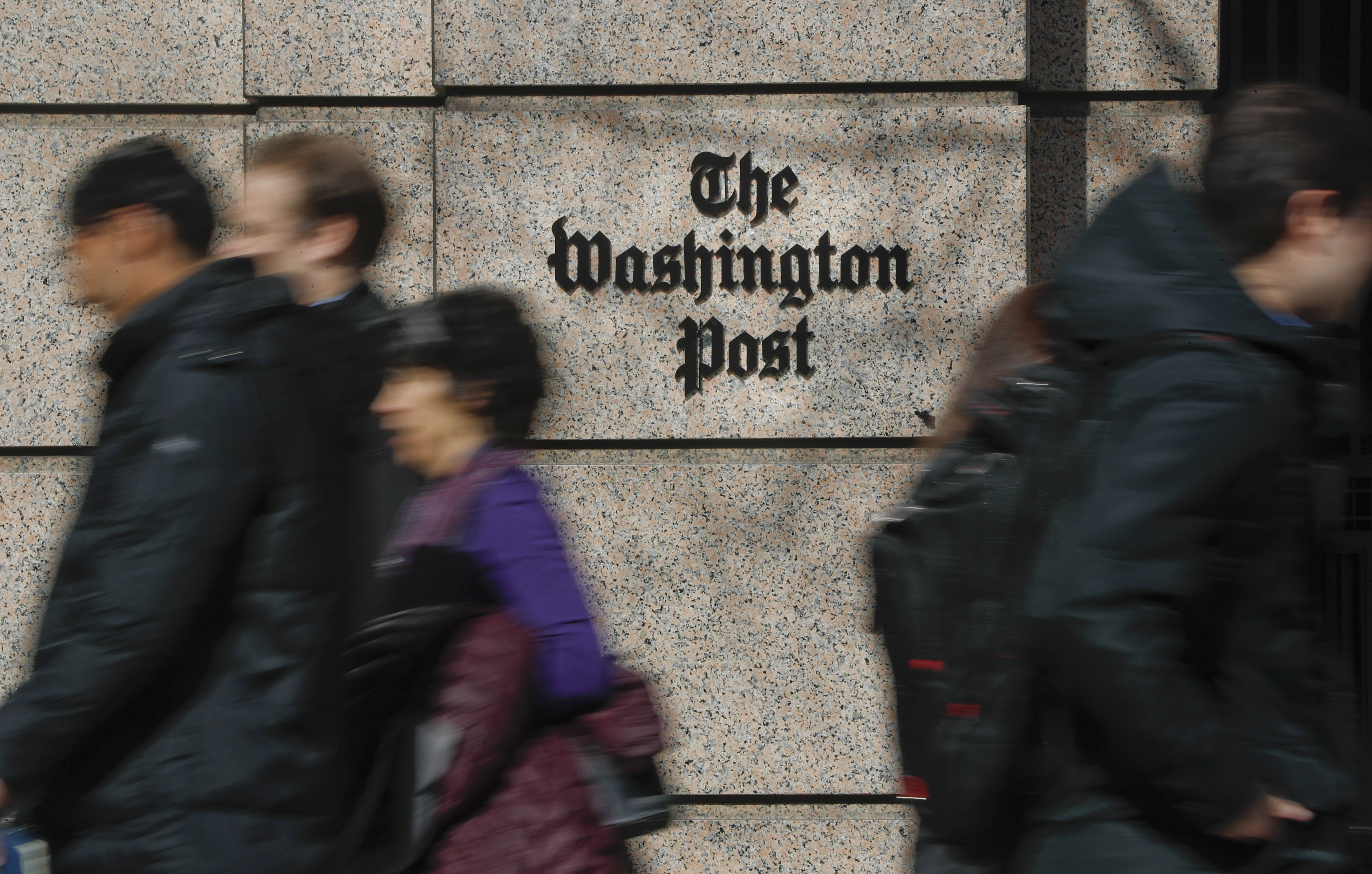 FILE - People walk by the One Franklin Square Building, home of The Washington Post newspaper, in downtown Washington, Feb. 21, 2019. (AP Photo/Pablo Martinez Monsivais, File)