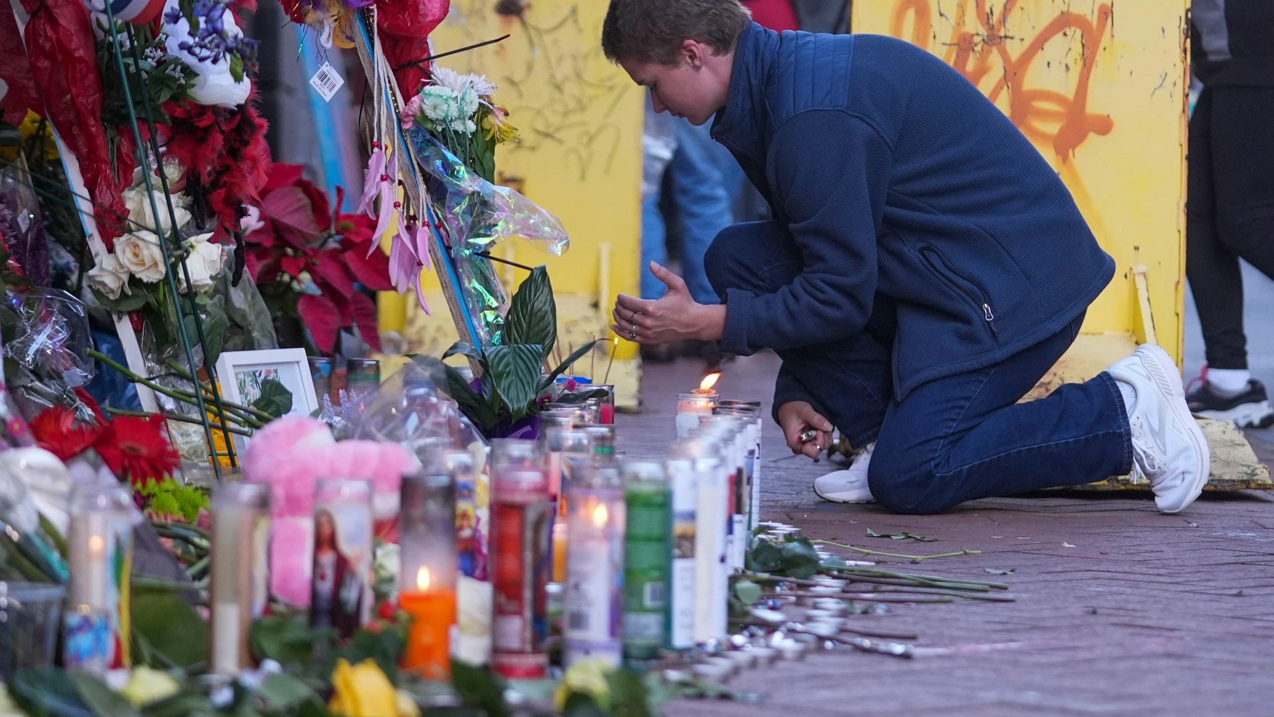 Nathan Williams, a University of New Orleans student, lights a candle at memorial on Bourbon Street for the victims of a deadly truck attack on New Year's Day in New Orleans, Friday, Jan. 3, 2025. (AP Photo/Gerald Herbert)