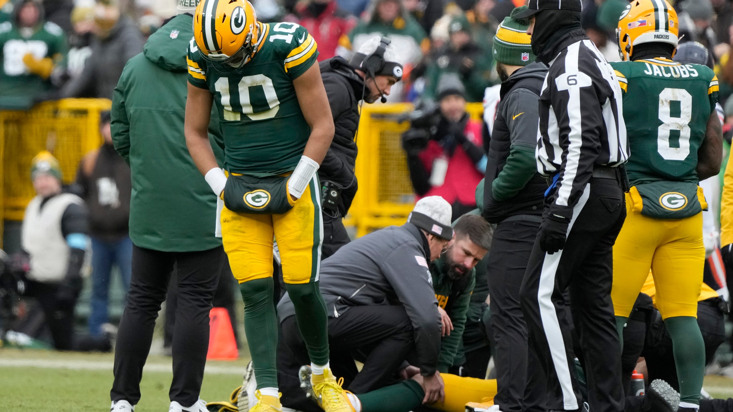 Green Bay Packers quarterback Jordan Love (10) reacts as wide receiver Christian Watson, bottom, is checked on during the first half of an NFL football game against the Chicago Bears, Sunday, Jan. 5, 2025, in Green Bay, Wis. (AP Photo/Morry Gash)