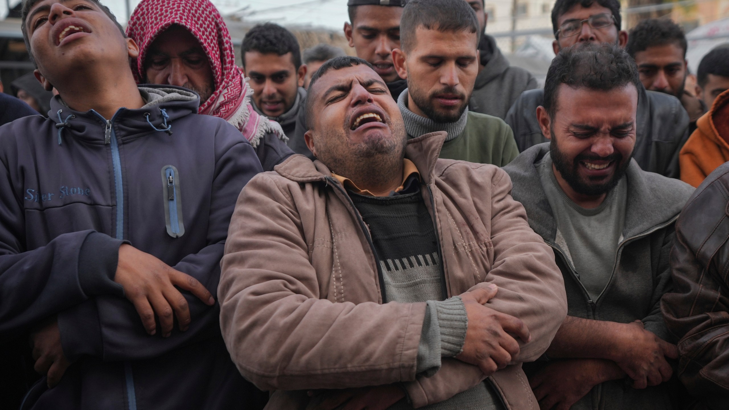 Palestinians mourn their relatives killed in the Israeli bombardment of the Gaza Strip, at Al-Aqsa Martyrs Hospital in Deir al-Balah, Sunday, Jan. 5, 2025. (AP Photo/Abdel Kareem Hana)