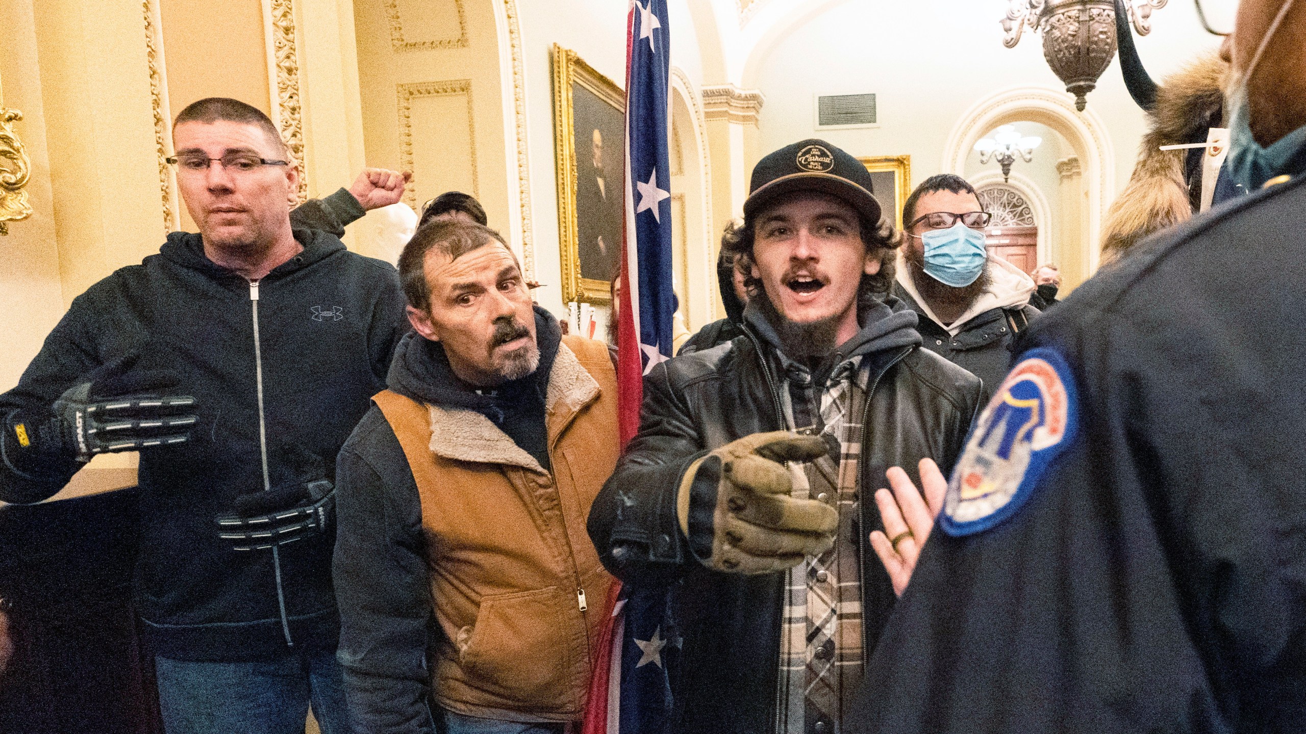 FILE - Violent protesters loyal to President Donald Trump, including Kevin Seefried, center, holding a Confederate battle flag, are confronted by U.S. Capitol Police officers outside the Senate Chamber inside the Capitol, Jan. 6, 2021 in Washington. (AP Photo/Manuel Balce Ceneta, File)