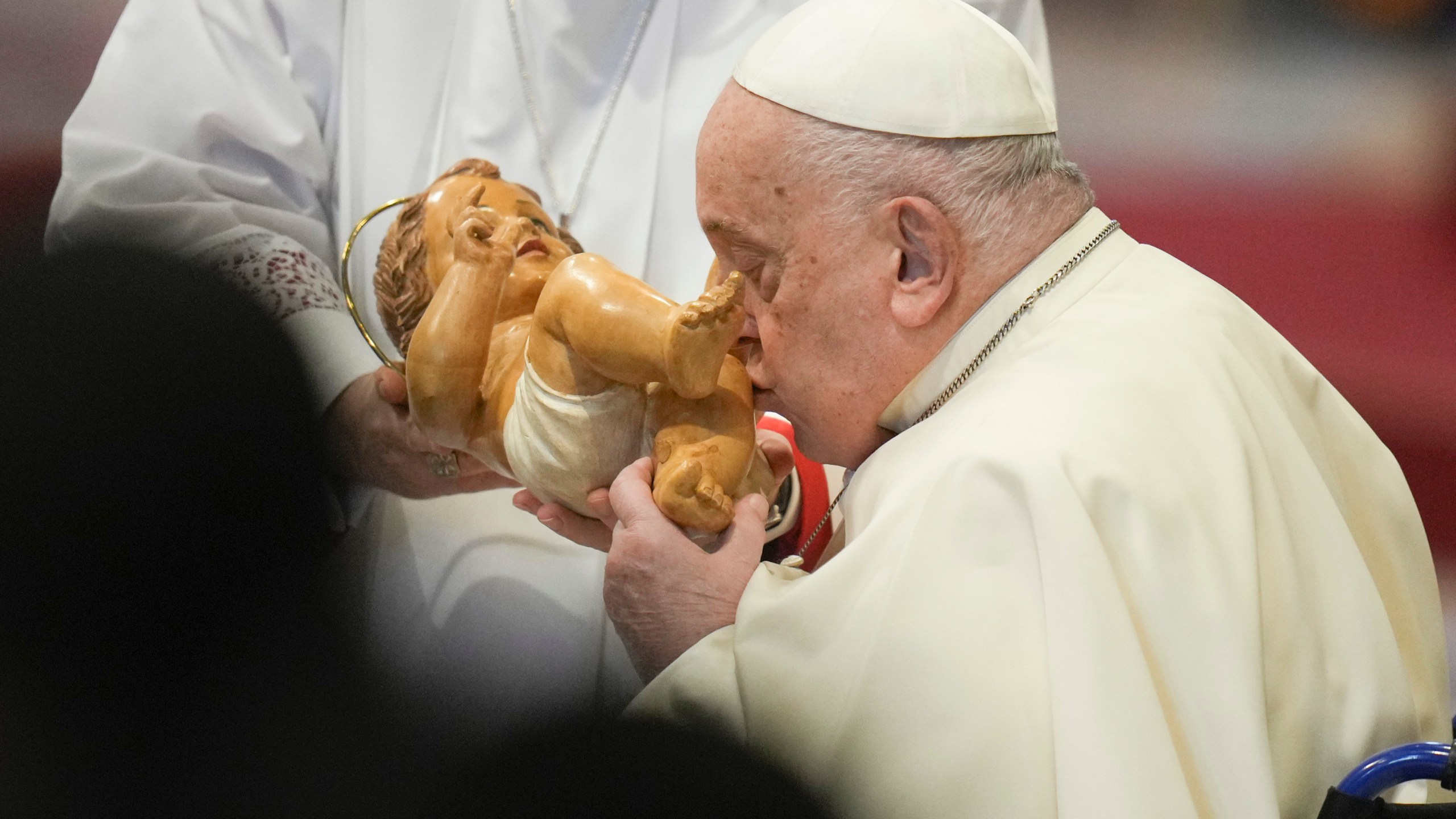 Pope Francis kisses the baby Jesus as he presides over an Epiphany mass in St.Peter's Basilica, at the Vatican, Monday, Jan. 6, 2025. (AP Photo/Alessandra Tarantino)