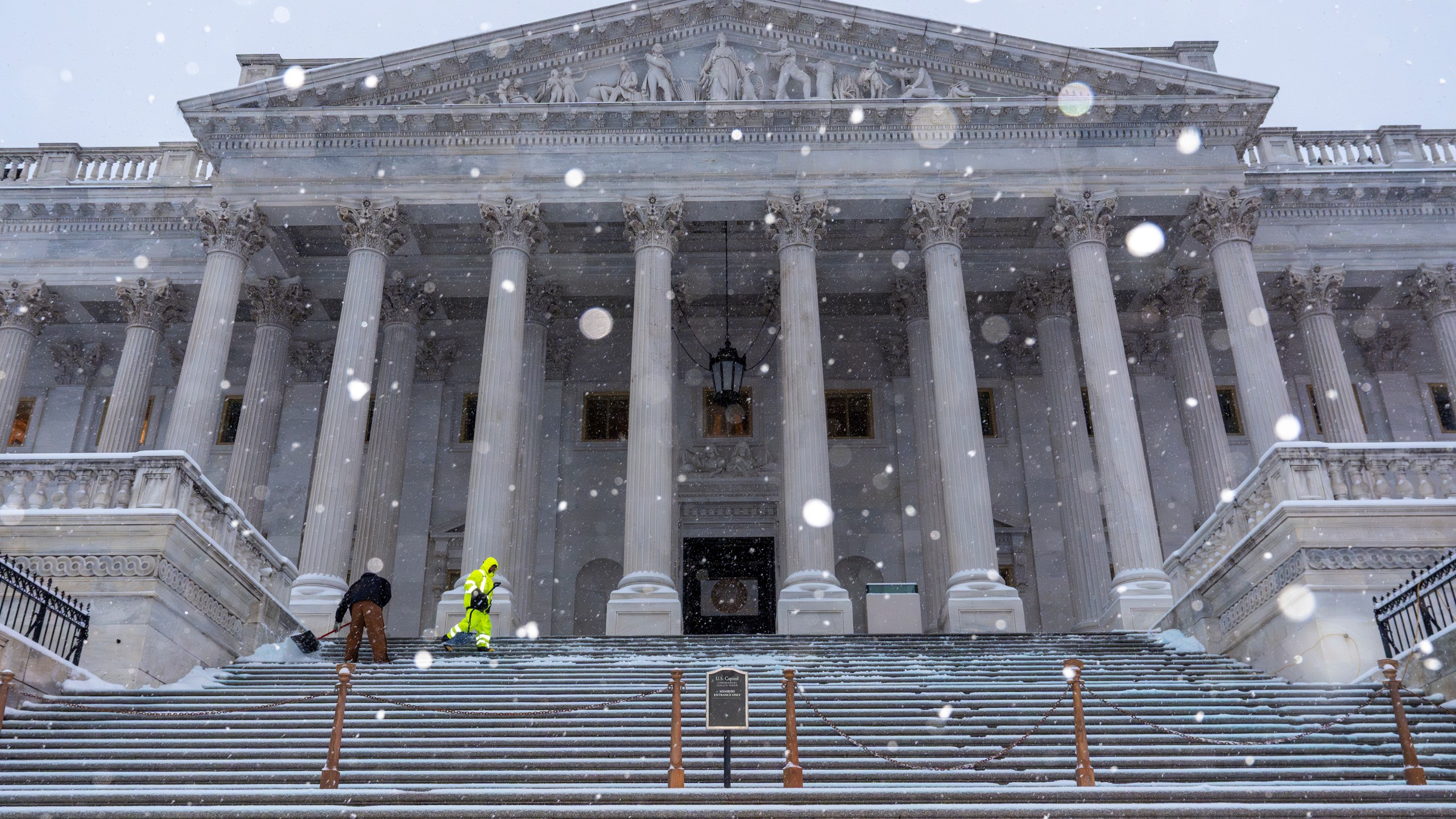 Workers clear steps at the Capitol as snow falls ahead of a joint session of Congress to certify the votes from the Electoral College in the presidential election, in Washington, Monday, Jan. 6, 2025. (AP Photo/J. Scott Applewhite)