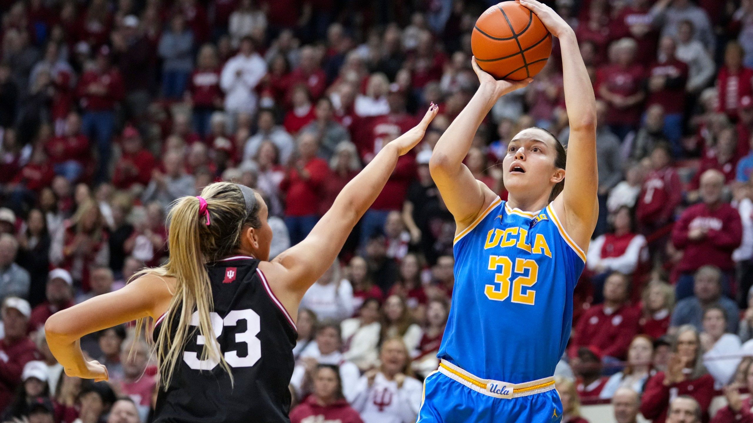 UCLA forward Angela Dugalic (32) shoots over Indiana guard Sydney Parrish (33) in the second half of an NCAA college basketball game in Bloomington, Ind., Saturday, Jan. 4, 2025. (AP Photo/Michael Conroy)