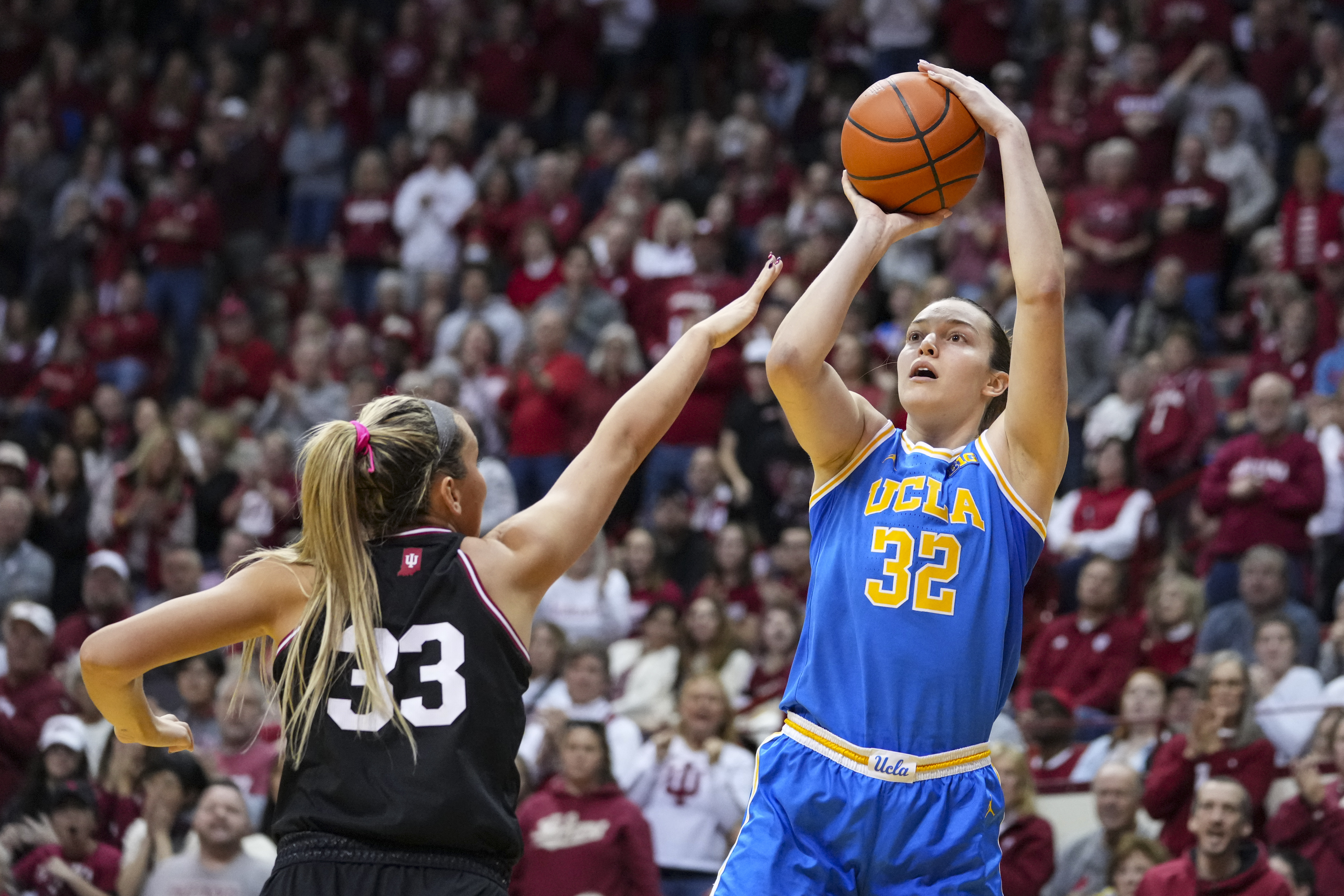 UCLA forward Angela Dugalic (32) shoots over Indiana guard Sydney Parrish (33) in the second half of an NCAA college basketball game in Bloomington, Ind., Saturday, Jan. 4, 2025. (AP Photo/Michael Conroy)