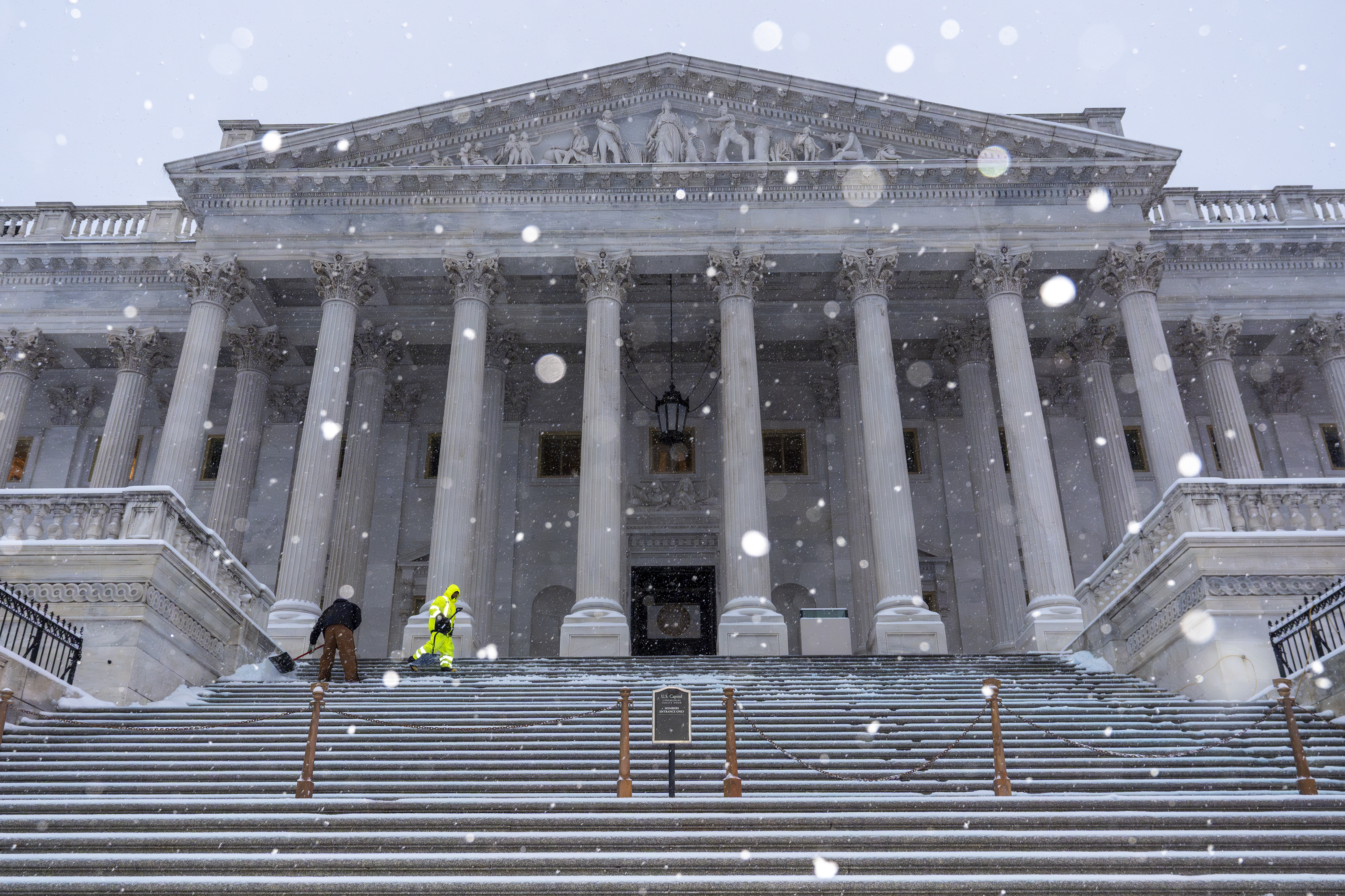 Workers clear steps at the Capitol as snow falls ahead of a joint session of Congress to certify the votes from the Electoral College in the presidential election, in Washington, Monday, Jan. 6, 2025. (AP Photo/J. Scott Applewhite)