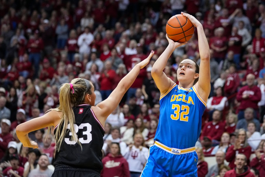 UCLA forward Angela Dugalic (32) shoots over Indiana guard Sydney Parrish (33) in the second half of an NCAA college basketball game in Bloomington, Ind., Saturday, Jan. 4, 2025. (AP Photo/Michael Conroy)