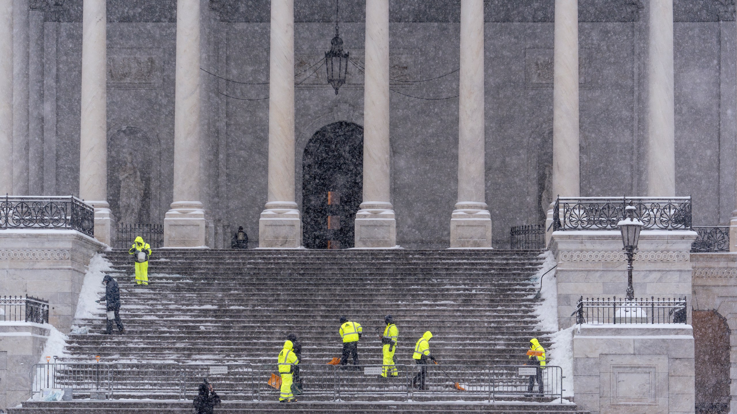 Workers clear steps at the Capitol as snow falls ahead of a joint session of Congress to certify the votes from the Electoral College in the presidential election, in Washington, Monday, Jan. 6, 2025. (AP Photo/J. Scott Applewhite)