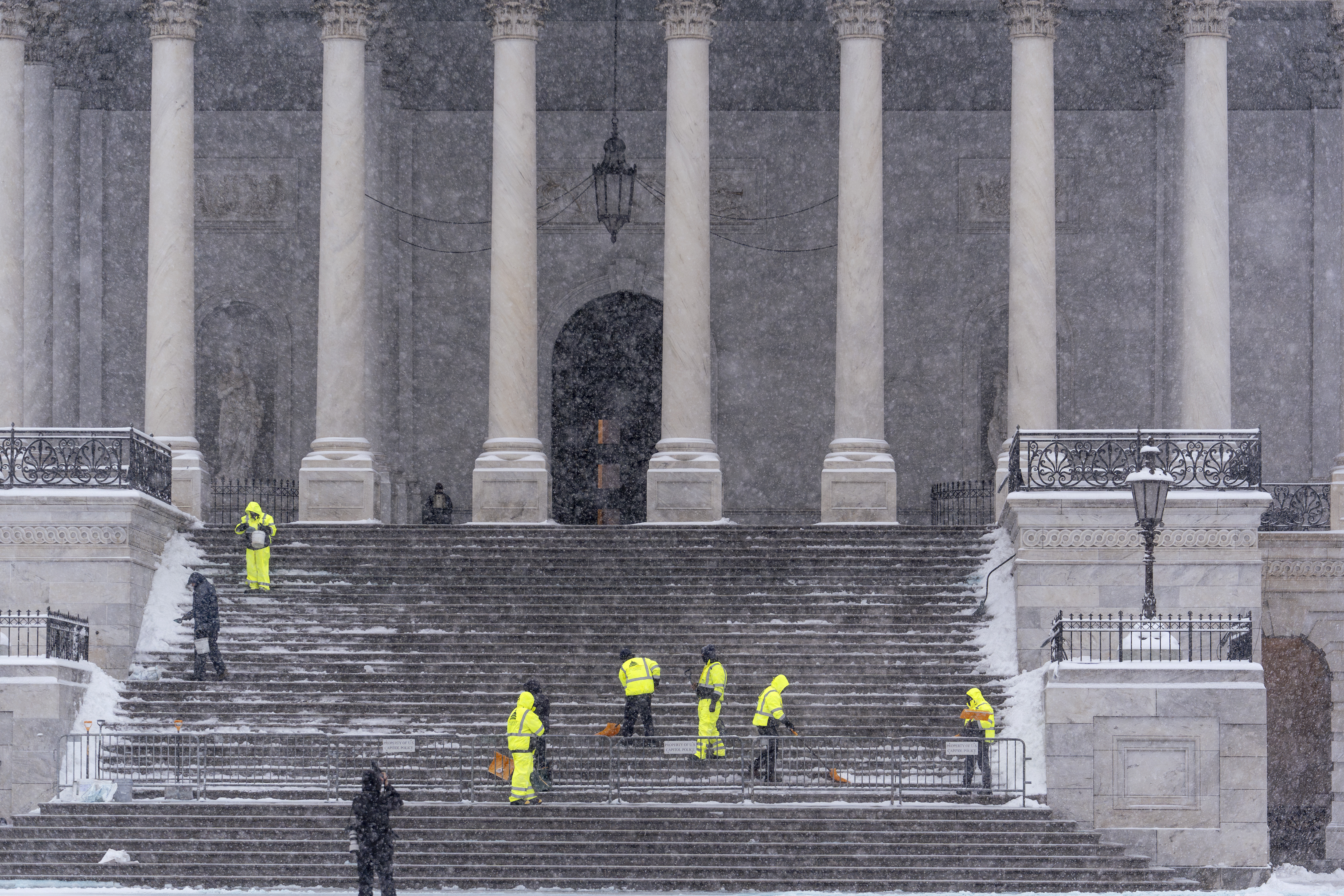 Workers clear steps at the Capitol as snow falls ahead of a joint session of Congress to certify the votes from the Electoral College in the presidential election, in Washington, Monday, Jan. 6, 2025. (AP Photo/J. Scott Applewhite)