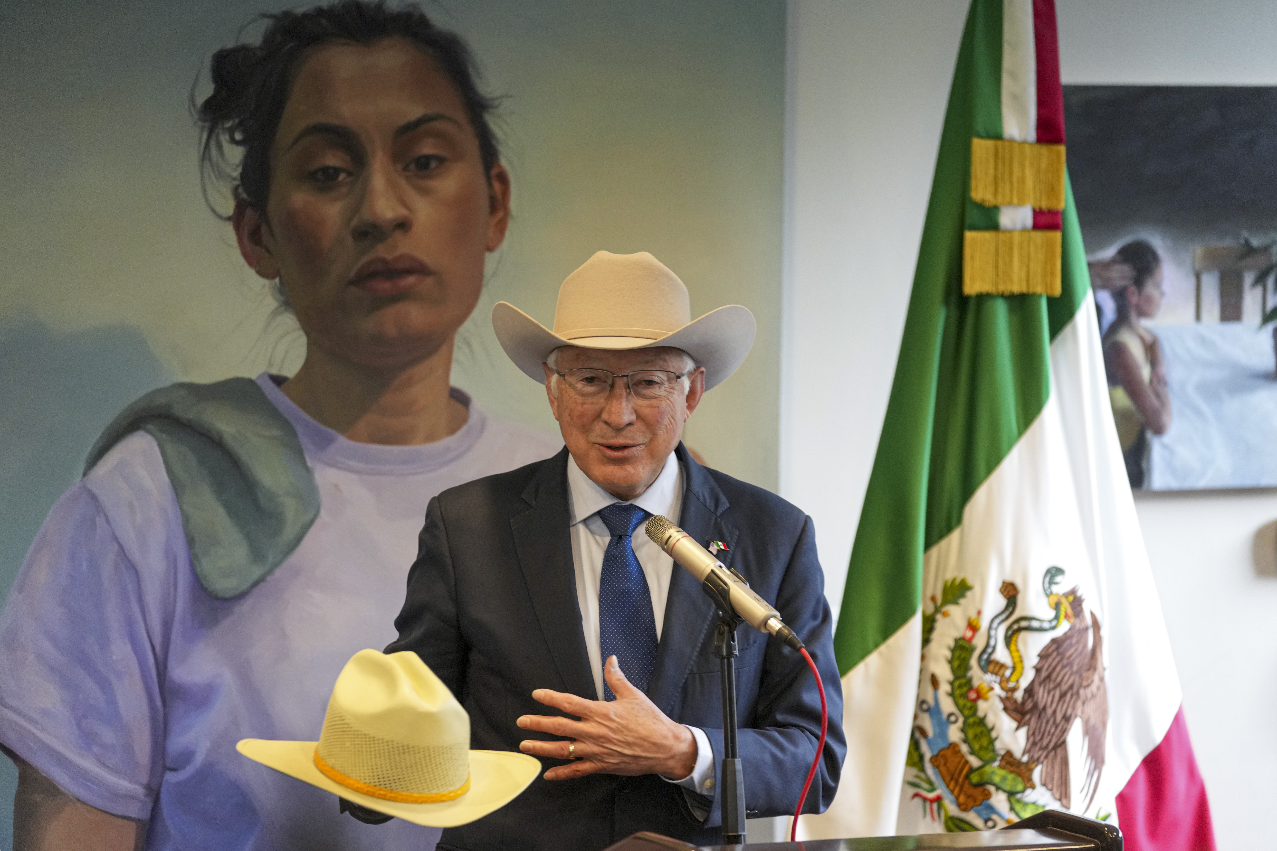 Outgoing U.S. Ambassador to Mexico Ken Salazar shows off one of his hats during the farewell news conference in Mexico City, Monday, Jan. 6, 2025. (AP Photo/Fernando Llano)