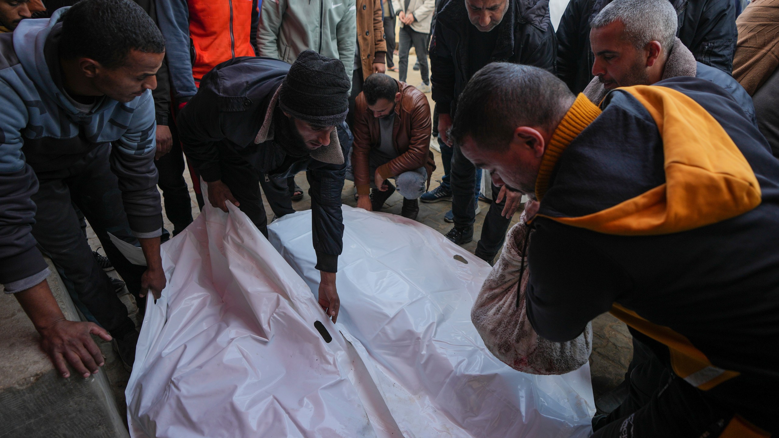 Mourners attend the funeral of three members of Imad Al-deen family who were killed in the Israeli bombardment in Bureij, central Gaza Strip, at Al-Aqsa Martyrs Hospital in Deir al-Balah, Monday, Jan. 6, 2025. (AP Photo/Abdel Kareem Hana)