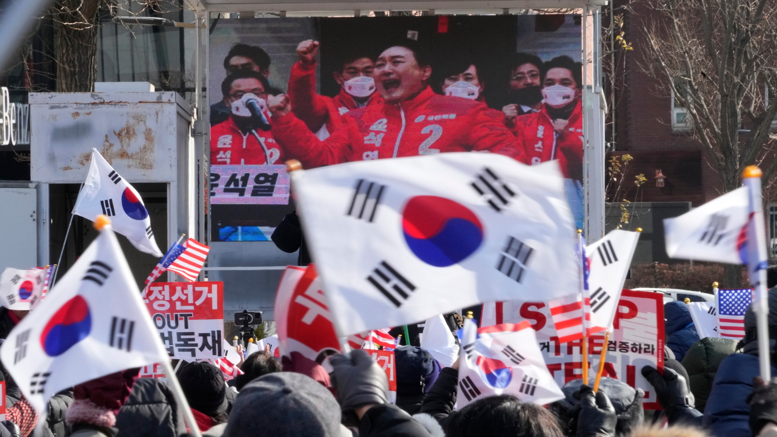 A TV screen shows a file image of South Korean President Yoon Suk Yeol as supporters of impeached Yoon stage a rally to oppose his impeachment near the presidential residence in Seoul, South Korea, Tuesday, Jan. 7, 2025. (AP Photo/Ahn Young-joon)