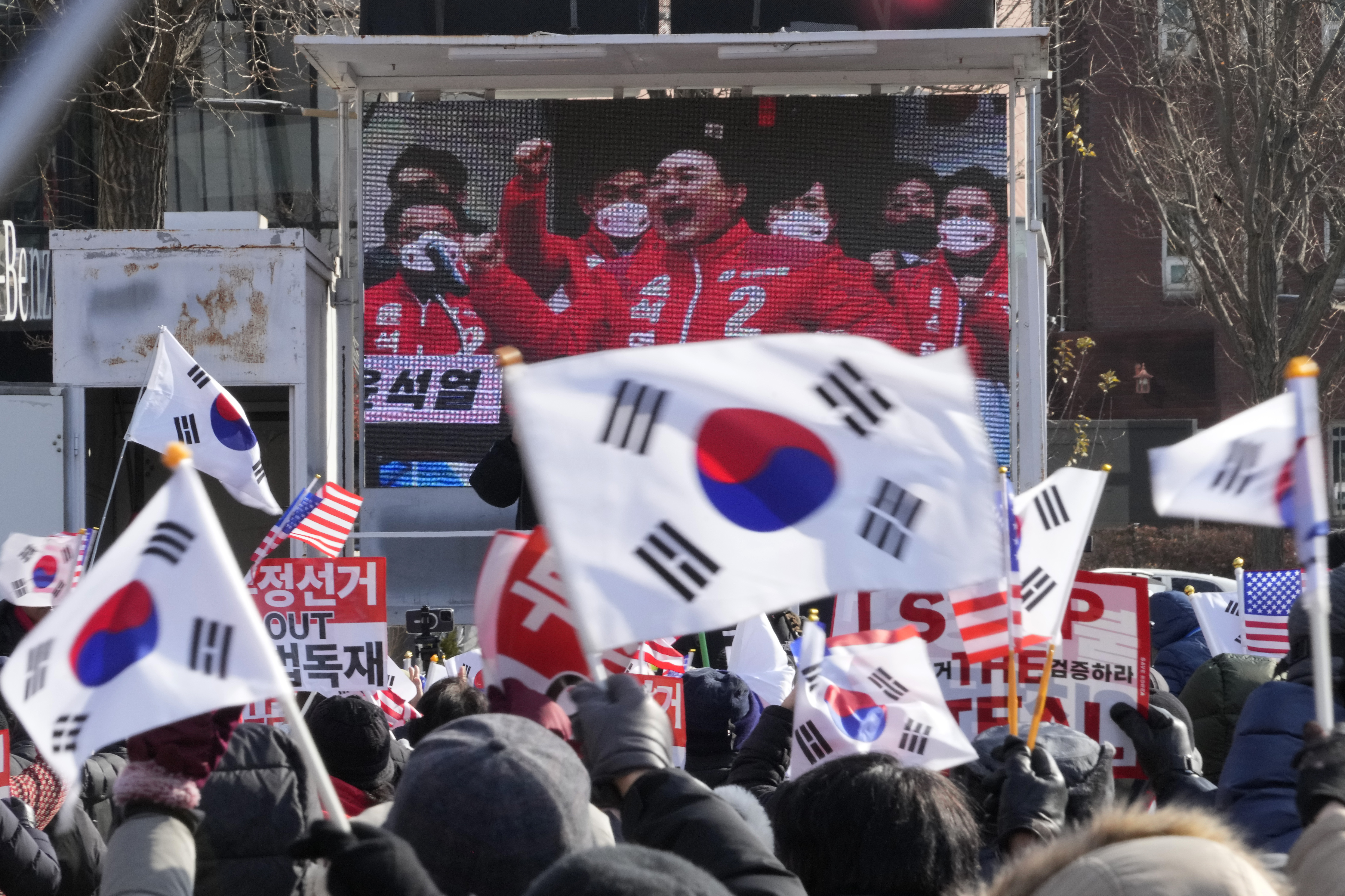 A TV screen shows a file image of South Korean President Yoon Suk Yeol as supporters of impeached Yoon stage a rally to oppose his impeachment near the presidential residence in Seoul, South Korea, Tuesday, Jan. 7, 2025. (AP Photo/Ahn Young-joon)