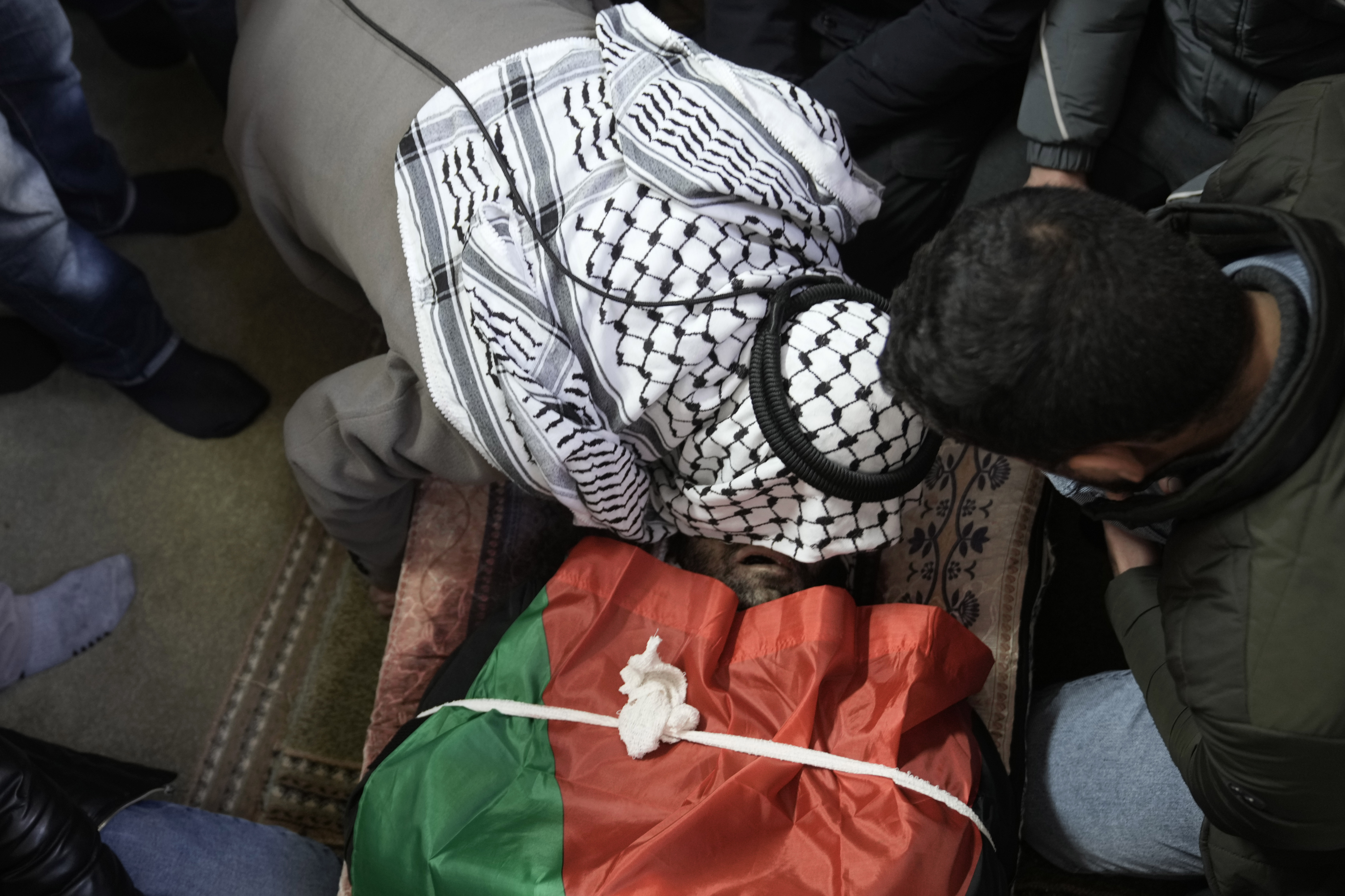 A mourner kisses the body of Jaafar Dababsah, a Palestinian Hamas commander killed in a raid by Israeli forces, during his funeral in the village of Talouza, near the West Bank city of Nablus, Tuesday, Jan. 7, 2025. (AP Photo/Majdi Mohammed)