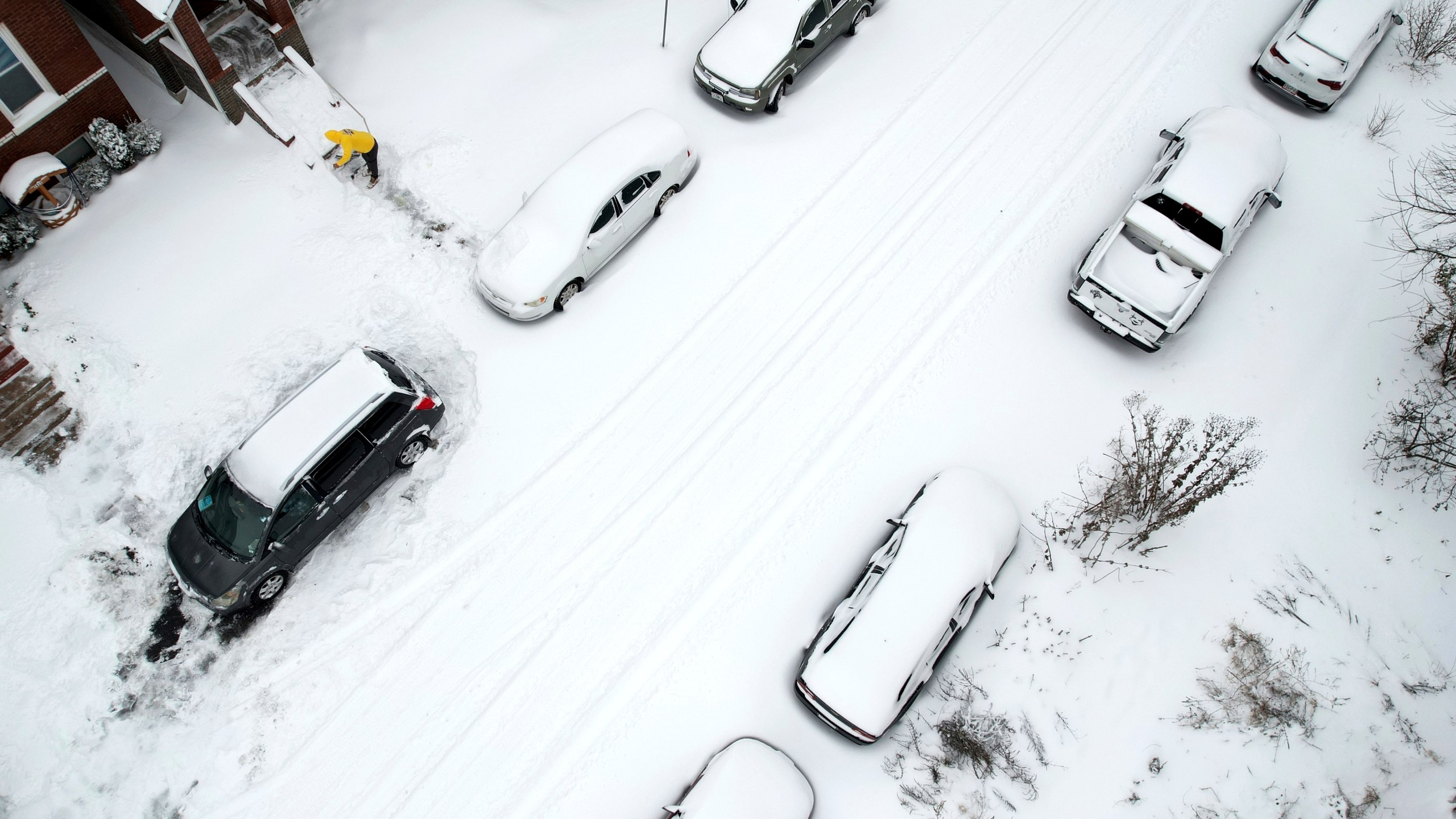 FILE - A person clears snow from front stairs of a home following a winter storm Monday, Jan. 6, 2025, in St. Louis. (AP Photo/Jeff Roberson, File)