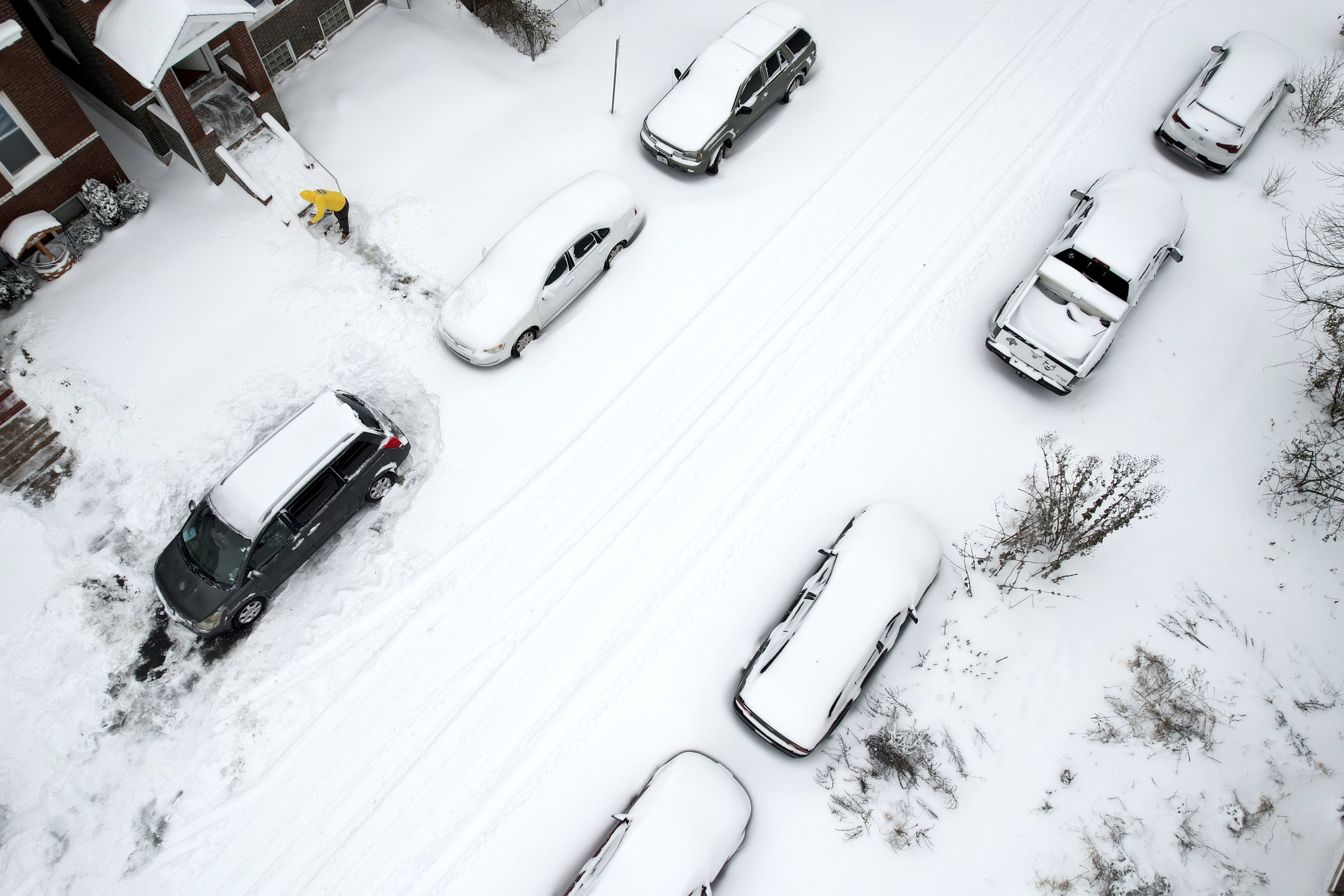 FILE - A person clears snow from front stairs of a home following a winter storm Monday, Jan. 6, 2025, in St. Louis. (AP Photo/Jeff Roberson, File)