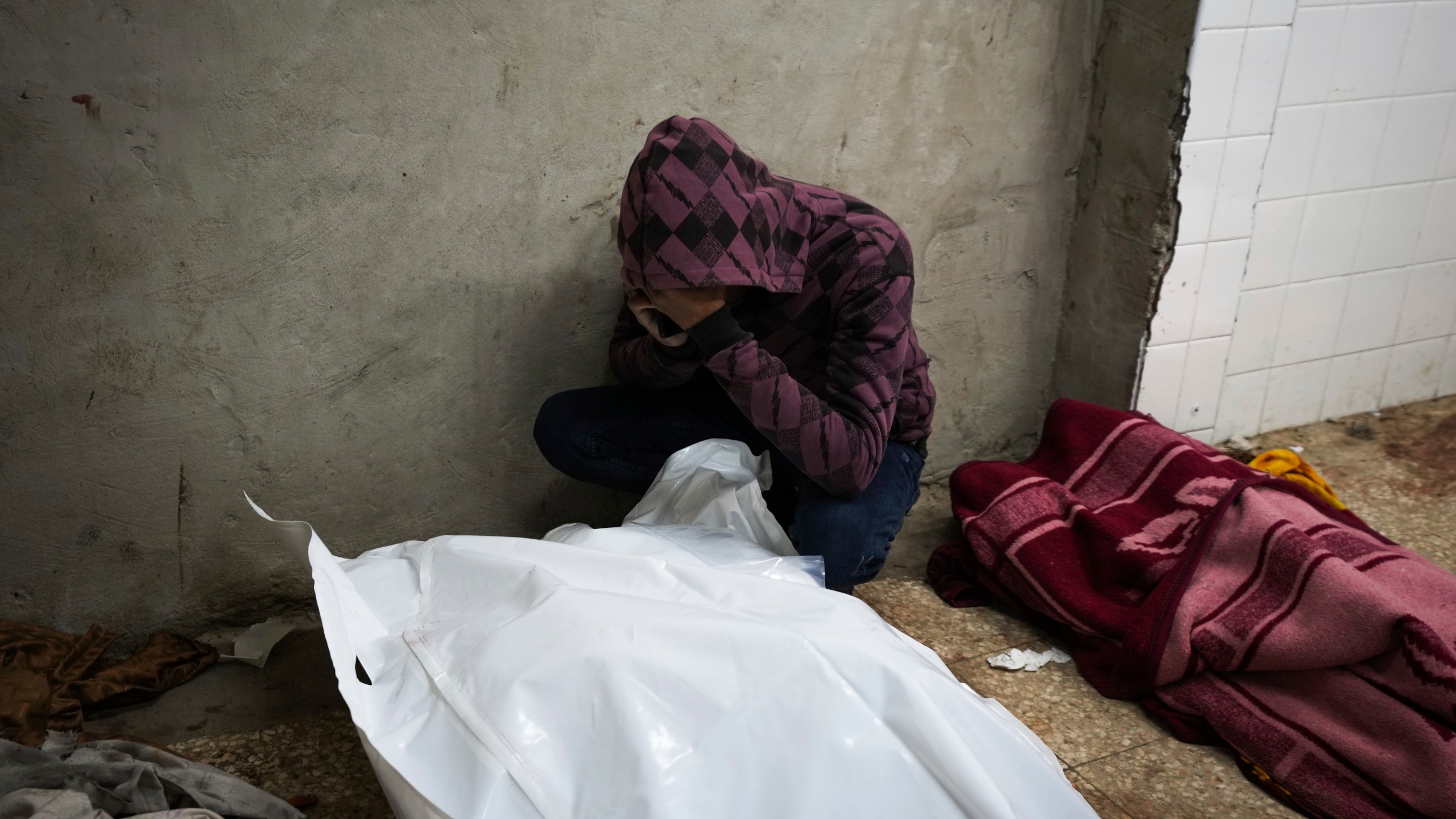 A man mourn over the bodies of two members of Abeid family who were killed in the Israeli bombardment in Maghazi, central Gaza Strip, at Al-Aqsa Martyrs Hospital in Deir al-Balah, Tuesday, Jan. 7, 2025. (AP Photo/Abdel Kareem Hana)