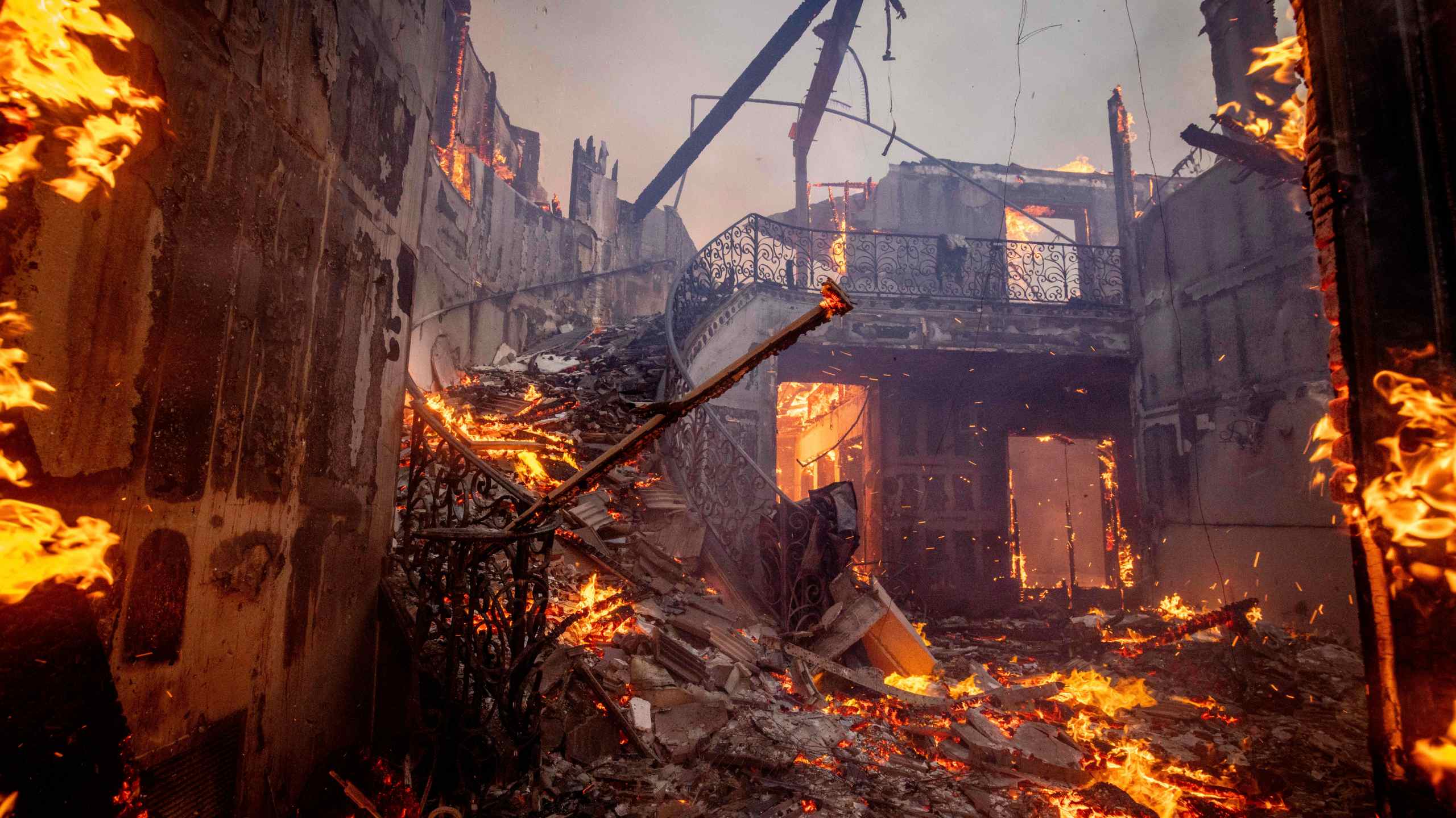 CORRECTS BYLINE FROM ETIENNE LAURENT TO ETHAN SWOPE - The Palisades Fire burns a residence in the Pacific Palisades neighborhood of Los Angeles, Tuesday, Jan. 7, 2025. (AP Photo/Ethan Swope)