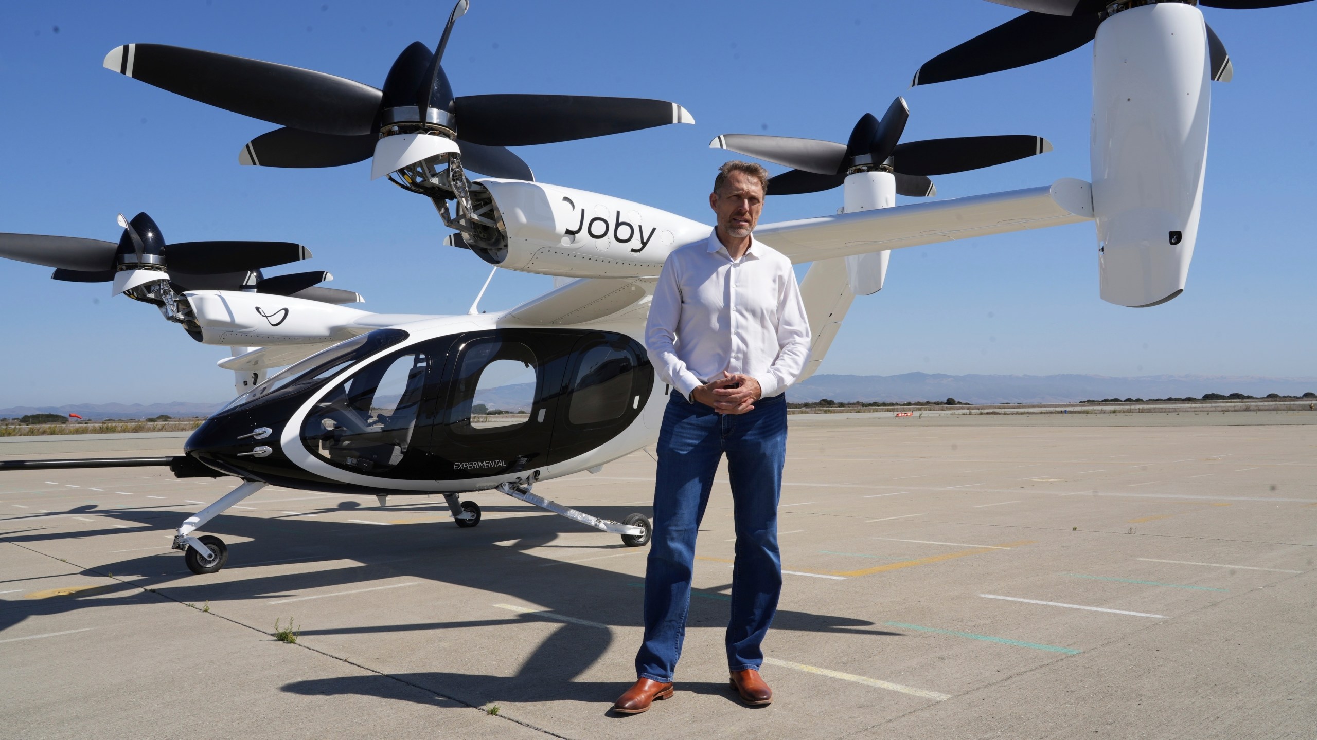 JoeBen Bevirt, CEO of Joby Aviation, stands next to an "electric vertical take-off and landing" aircraft, also known as an eVTOL, in Marina, Calif. on Monday, Oct. 7, 2024. (AP Photo/Terry Chea)