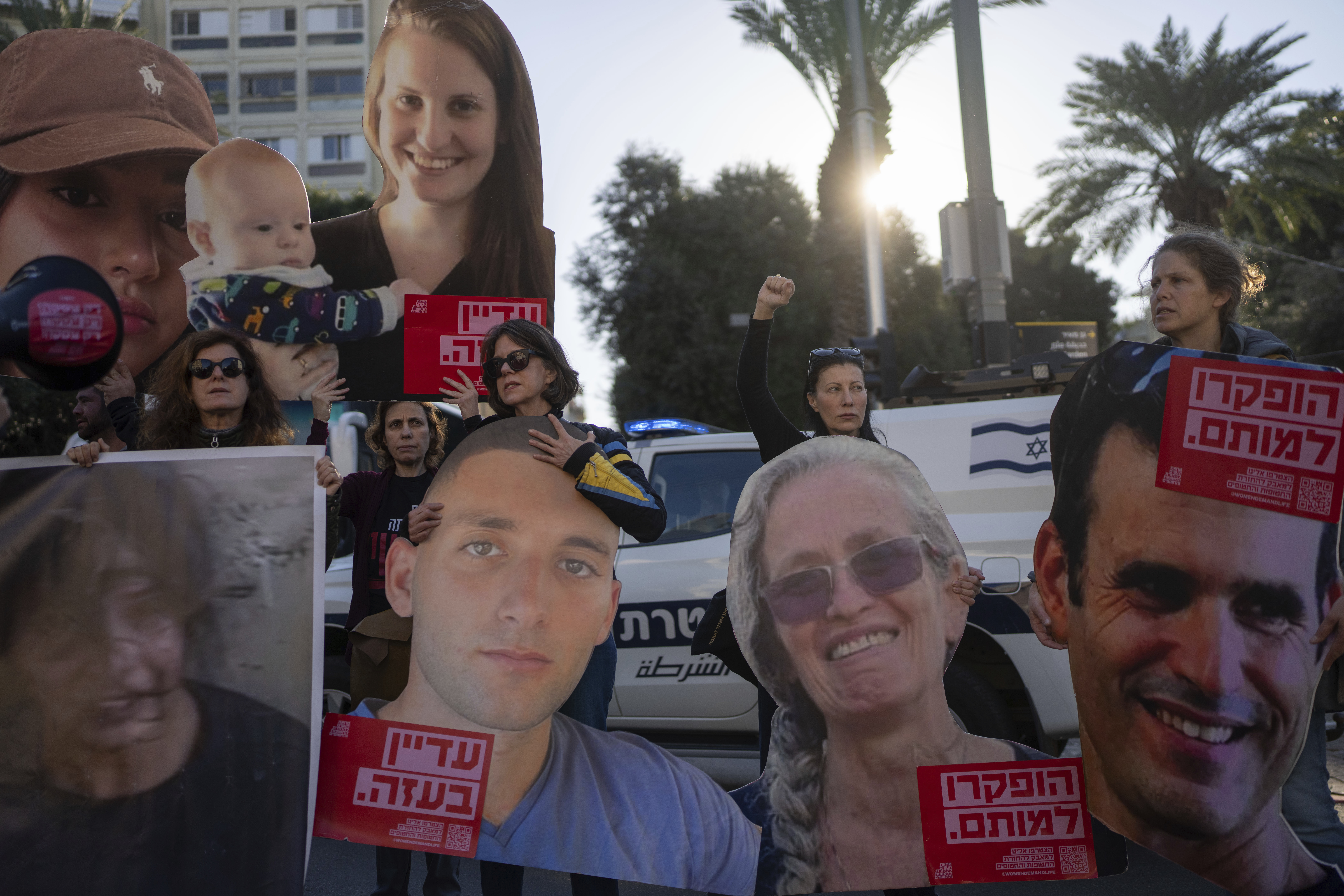 Relatives and supporters of Israeli hostages held by Hamas in Gaza hold photos of their loved ones during a protest calling for their return, in Tel Aviv, Israel, Wednesday, Jan. 8, 2025. (AP Photo/Ohad Zwigenberg)