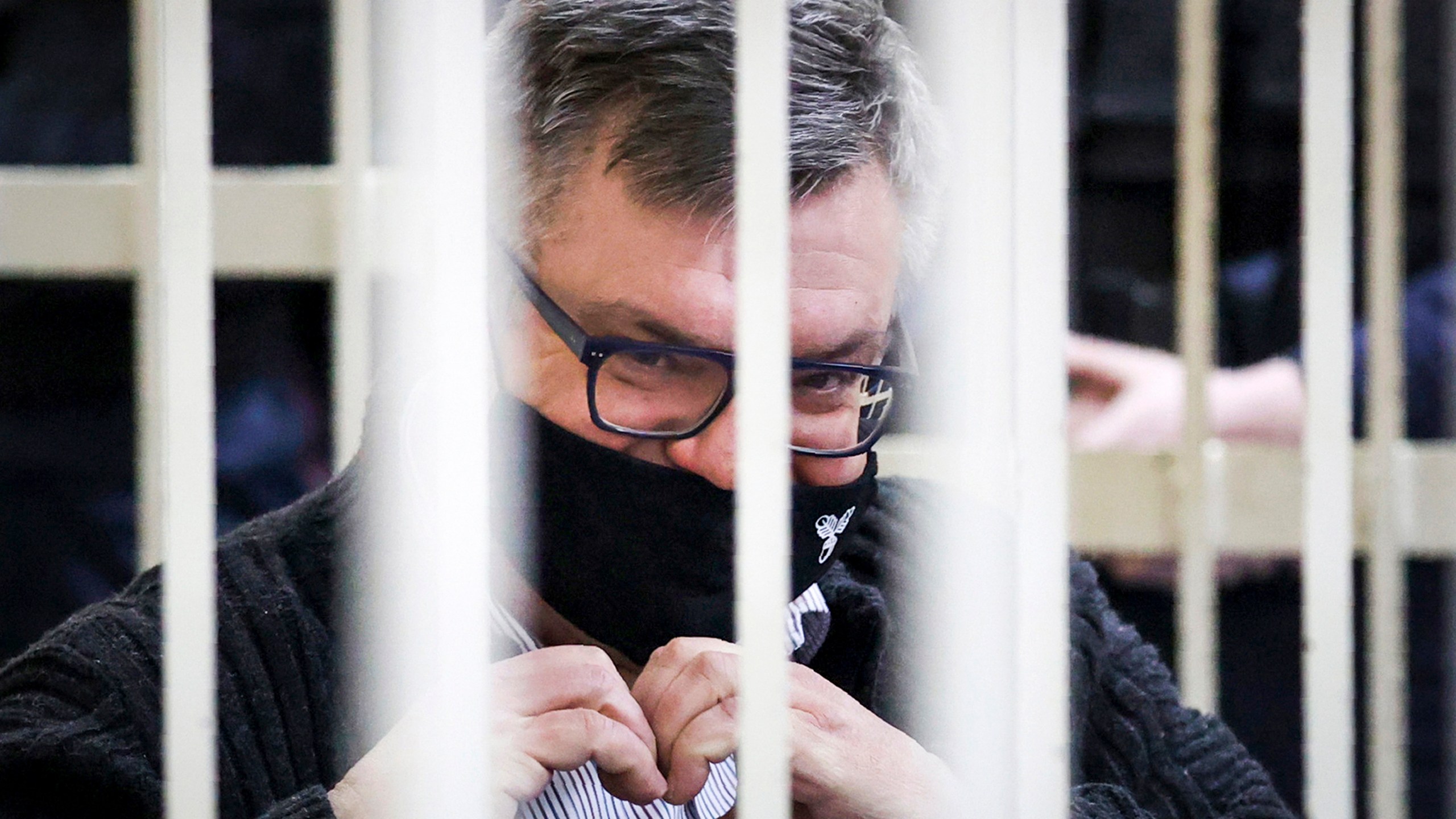 FILE - Viktar Babaryka, a former presidential hopeful, makes a heart gesture while sitting in a defendants’ cage during his trial in Minsk, Belarus, on Feb. 17, 2021. (Oksana Manchuk/BelTA Pool Photo via AP)