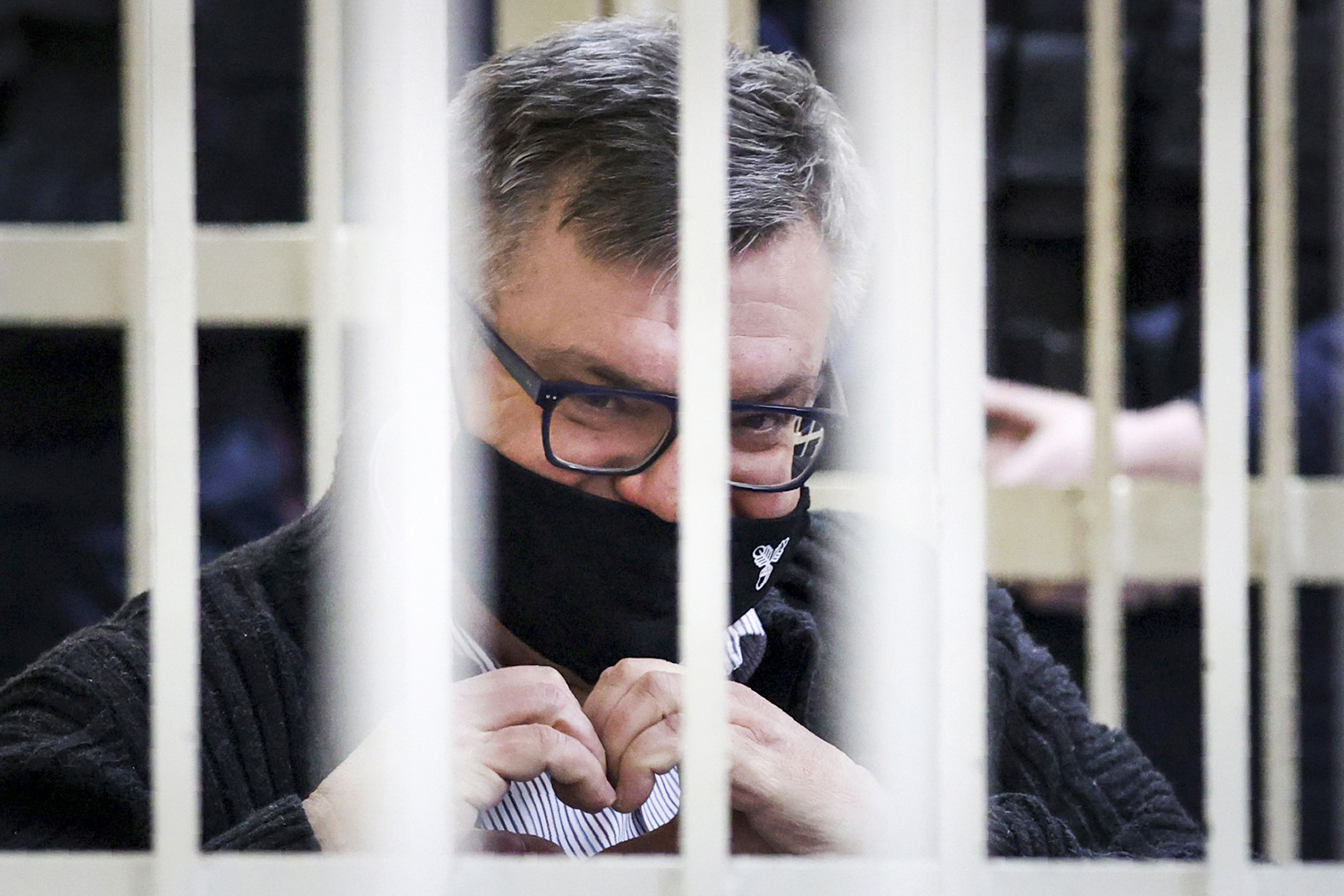 FILE - Viktar Babaryka, a former presidential hopeful, makes a heart gesture while sitting in a defendants’ cage during his trial in Minsk, Belarus, on Feb. 17, 2021. (Oksana Manchuk/BelTA Pool Photo via AP)