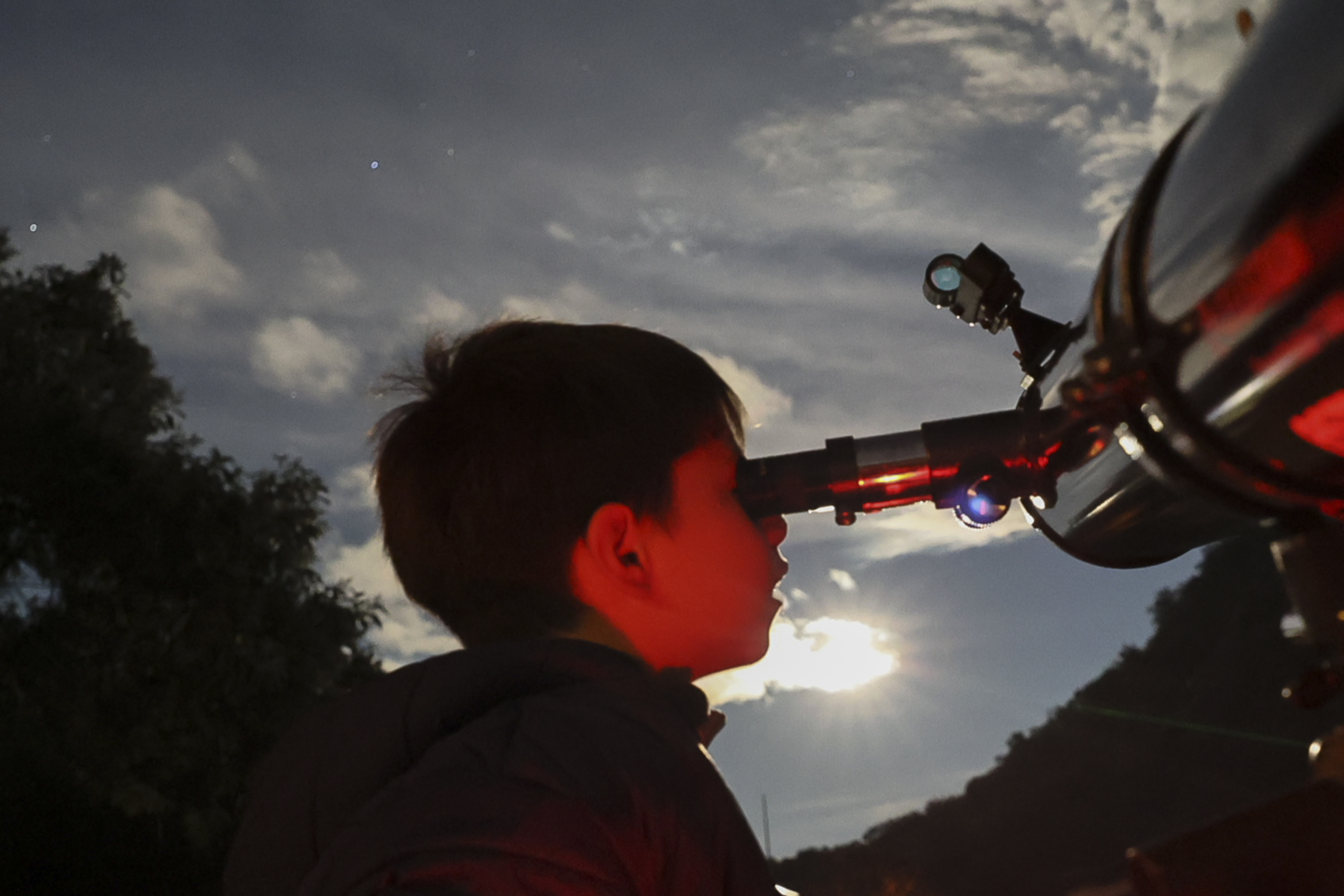 FILE - A youth looks through a telescope during a stargazing and comet-watching gathering at Joya-La Barreta Ecological Park in Queretaro, Mexico, Saturday, Oct. 19, 2024. (AP Photo/Ginnette Riquelme, File)