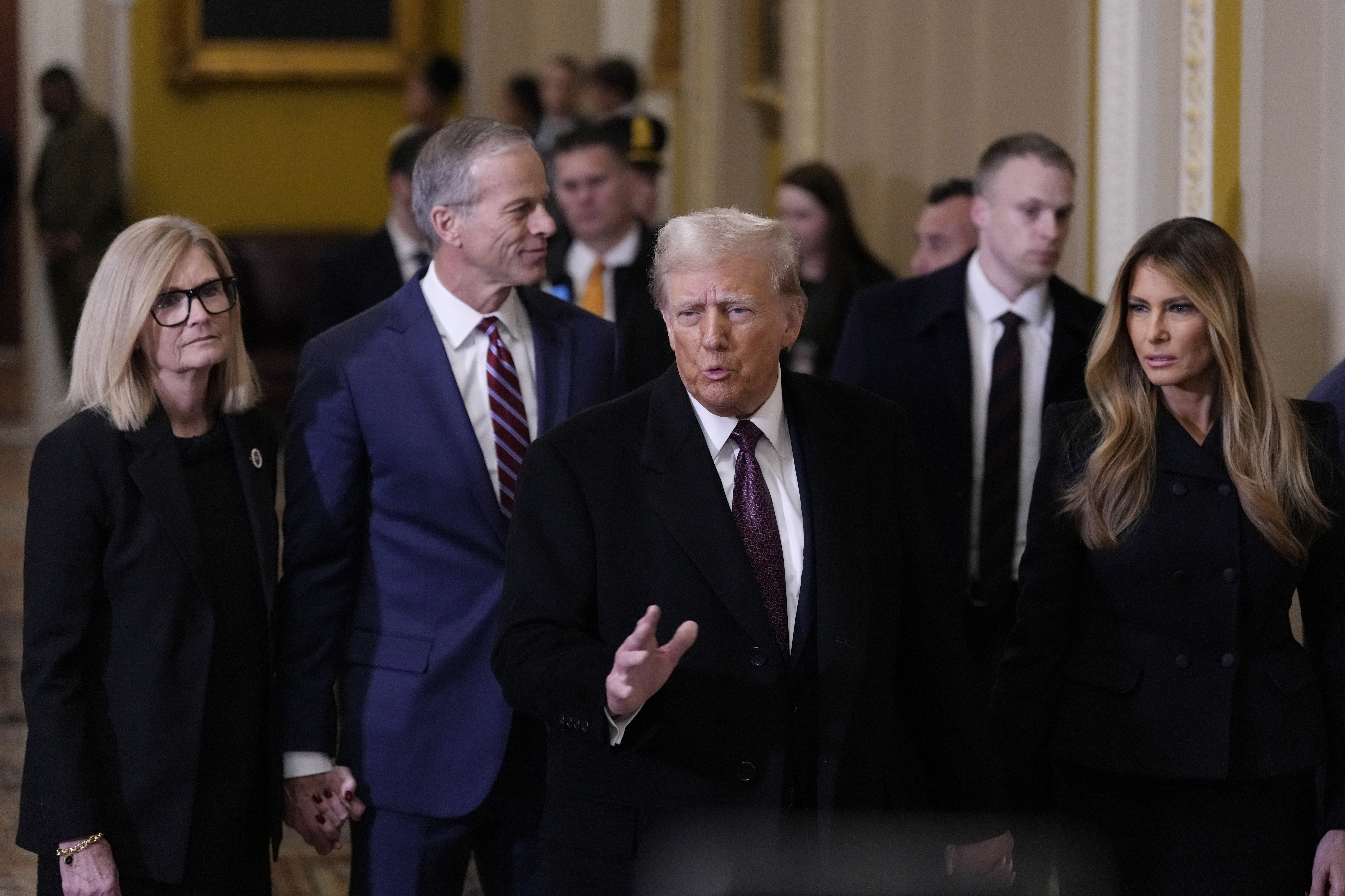 President-elect Donald Trump, center, and his wife Melania, walk with Majority Leader John Thune, R-S.D., and his wife, Kimberley, to meet with Senate Republican at the U.S. Capitol, Wednesday, Jan. 8, 2025, in Washington. (AP Photo/Steve Helber)