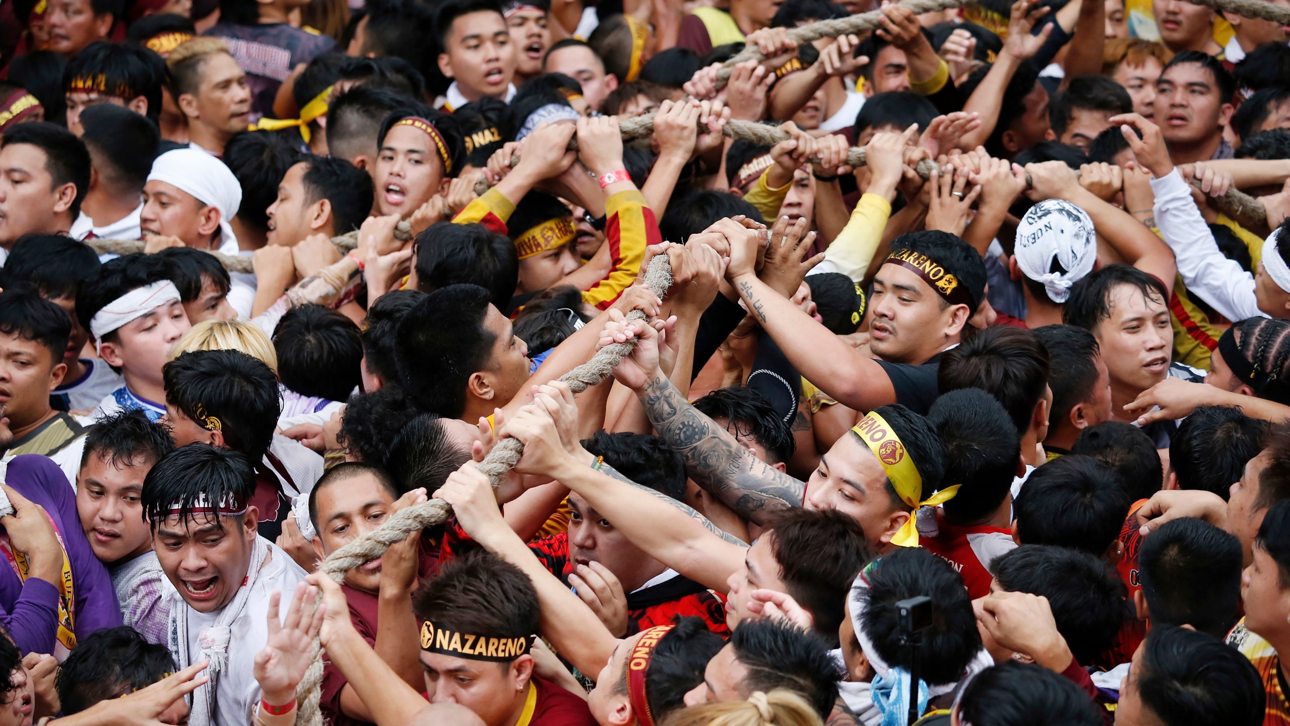 Devotees grab the rope as they pull a glass-covered carriage carrying the image of Jesus Nazareno during its annual procession in Manila, Philippines Thursday, Jan. 9, 2025. (AP Photo/Basilio Sepe)