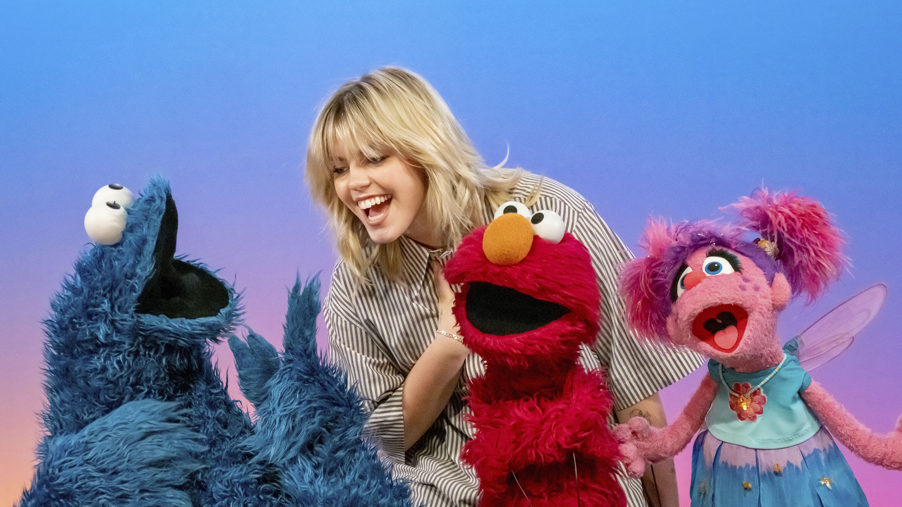 This image released by Sesame Workshop shows actor-singer Renee Rapp with muppet characters Cookie Monster, from left, Elmo and Abby Cadabby on the set of "Sesame Street." (Richard Termine/Sesame Workshop via AP)