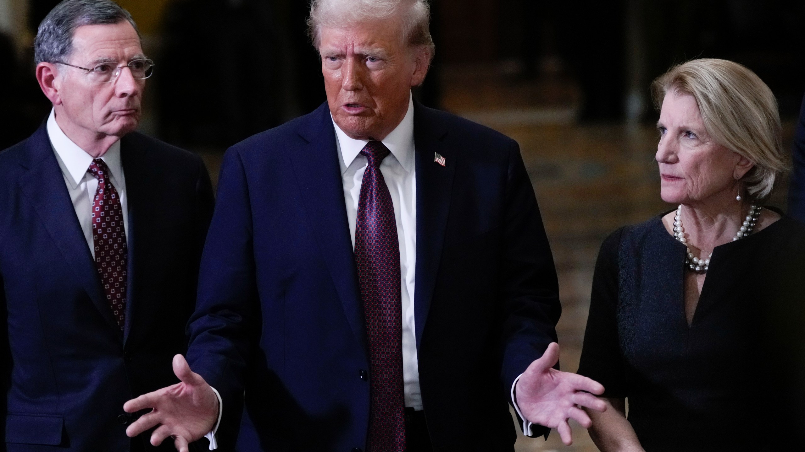 President-elect Donald Trump, flanked by Sen. John Barrasso, R-Wyo., left, Sen. Shelley Moore Capito, R-W.Va., right, talks to reporters after a meeting with Republican leadership at the Capitol on Wednesday, Jan. 8, 2025, in Washington. (AP Photo/Steve Helber)