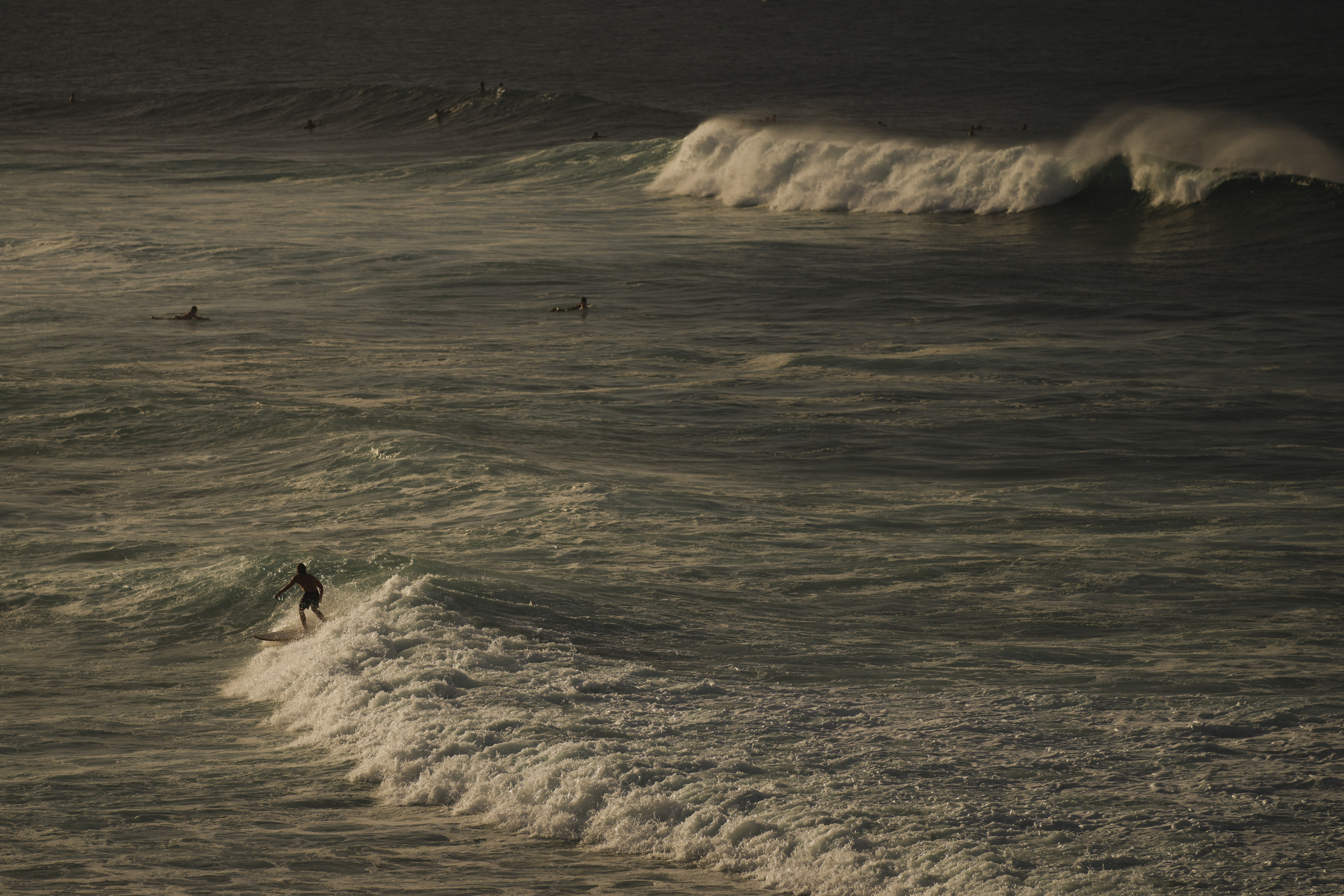 FILE - Surfers catch waves in the Pacific Ocean off of Ho'okipa Beach Park, Nov. 22, 2024, near Paia, Hawaii. (AP Photo/Lindsey Wasson, File)