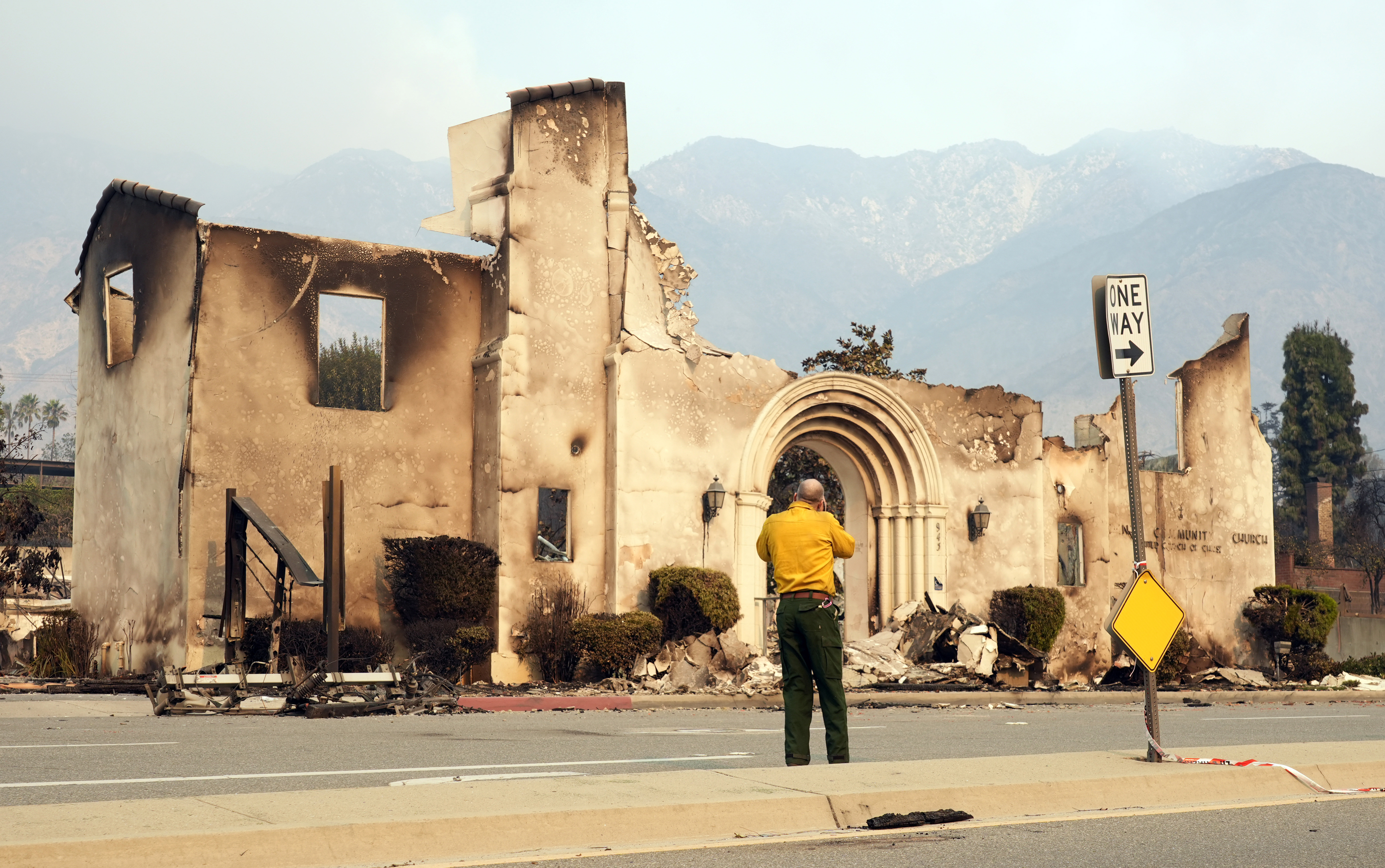 A man photographs the destroyed Altadena Community Church, Thursday, Jan. 9, 2025, in the Altadena section of Pasadena, Calif. (AP Photo/Chris Pizzello)