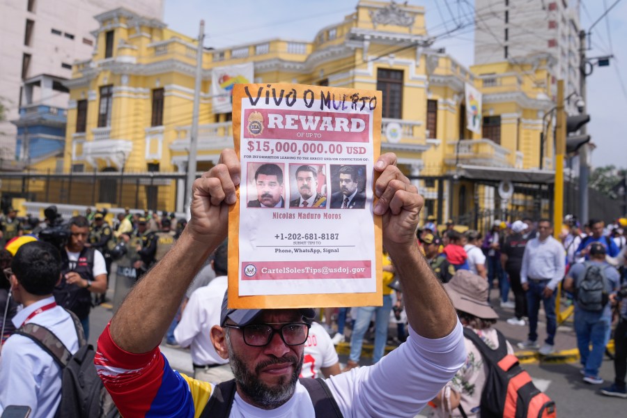 Venezuelan Tulio Rodriguez holds a wanted sign of Venezuelan President Nicolas Maduro that reads in Spanish: "Reward. Dead or alive" outside the Venezuelan embassy in Lima, Peru, Thursday, Jan. 9, 2025, the day before his inauguration for a third term. (AP Photo/Martin Mejia)