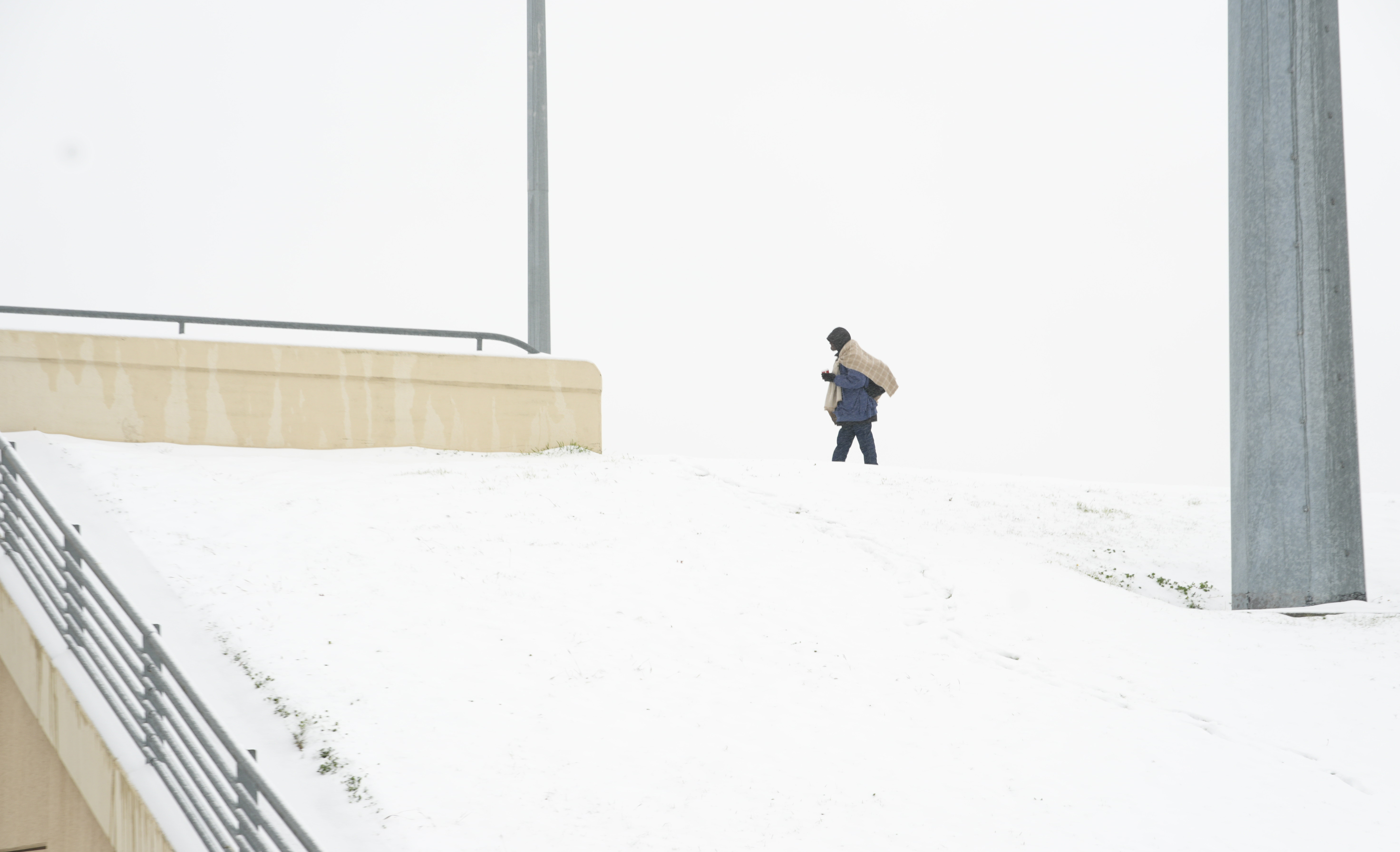 Frank Burnett walks on a snow covered overpass Thursday, Jan. 9, 2025, in Plano, Texas. (AP Photo/LM Otero)